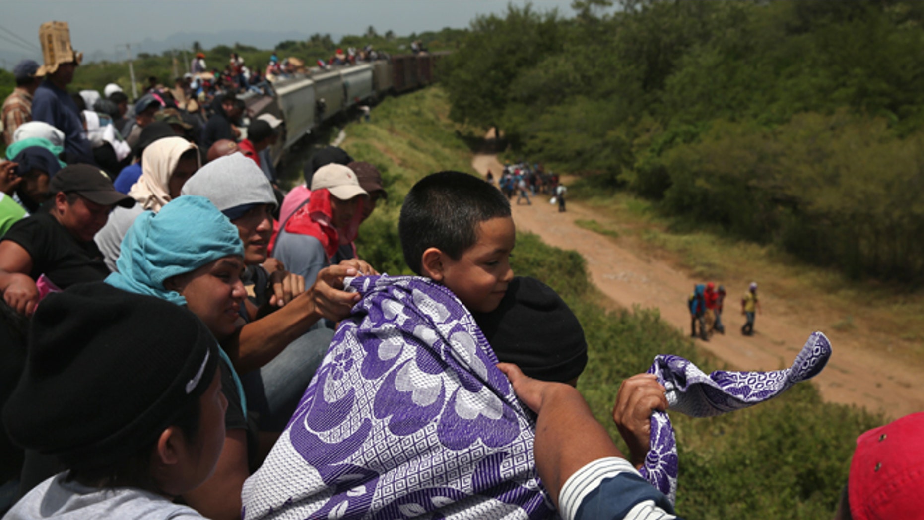 Central American immigrants arrive on top of a freight train for a stop on August 6, 2013 in Ixtepec, Mexico.