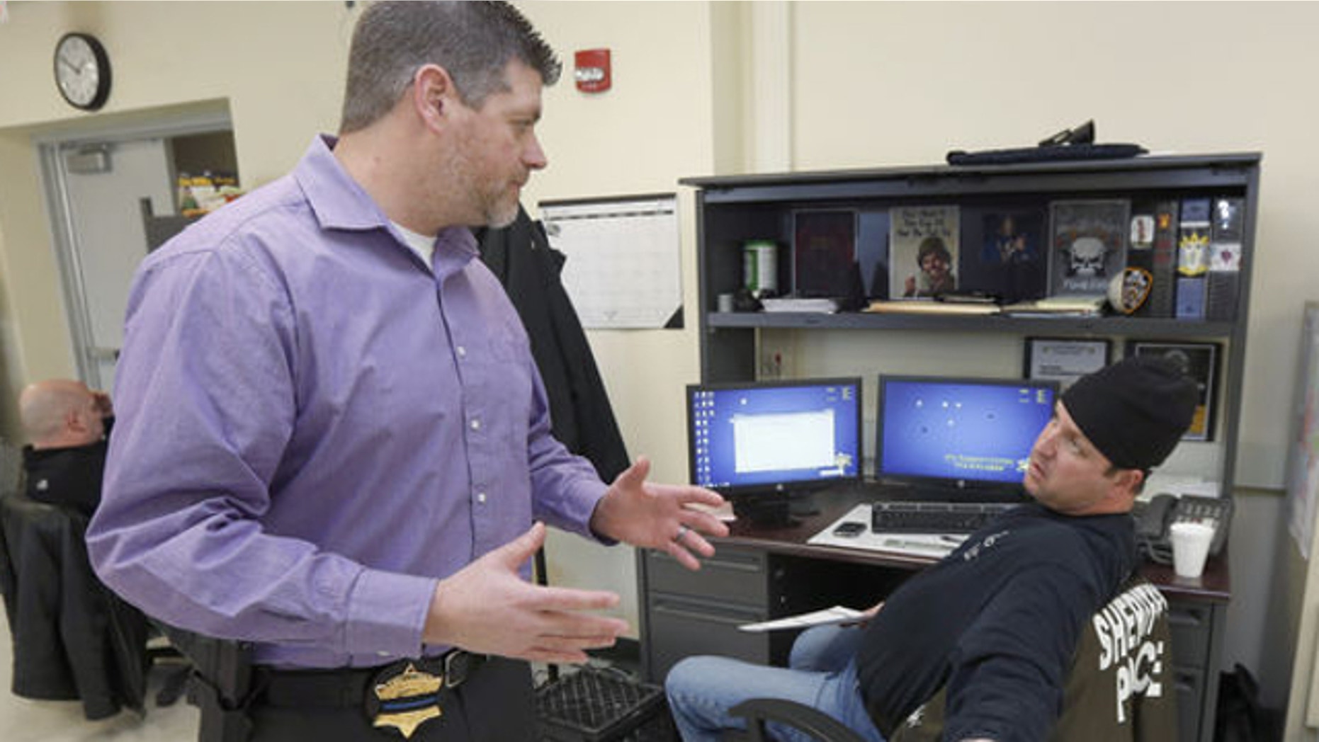 Jan. 8, 2014: John Blair, left, executive director of the Cook County Sheriff's Office Intelligence Center, consults with Officer John Slepski about a firearms background check Slepski is performing at the center in Chicago.