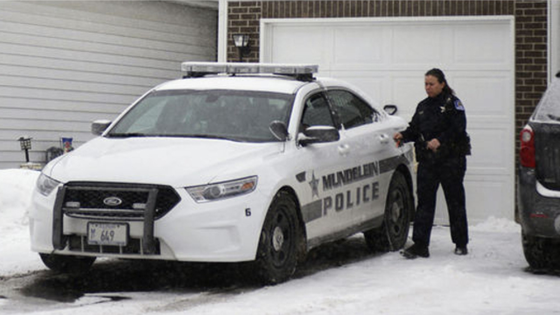 Jan. 22, 2014: A police officer is seen outside a home in Mundelein, Ill., where an 11-year-old girl was stabbed to death on Tuesday, Jan. 21. The Lake County State's Attorney's office said Wednesday they've approved a first-degree murder charge against a 14-year-old girl in the killing.