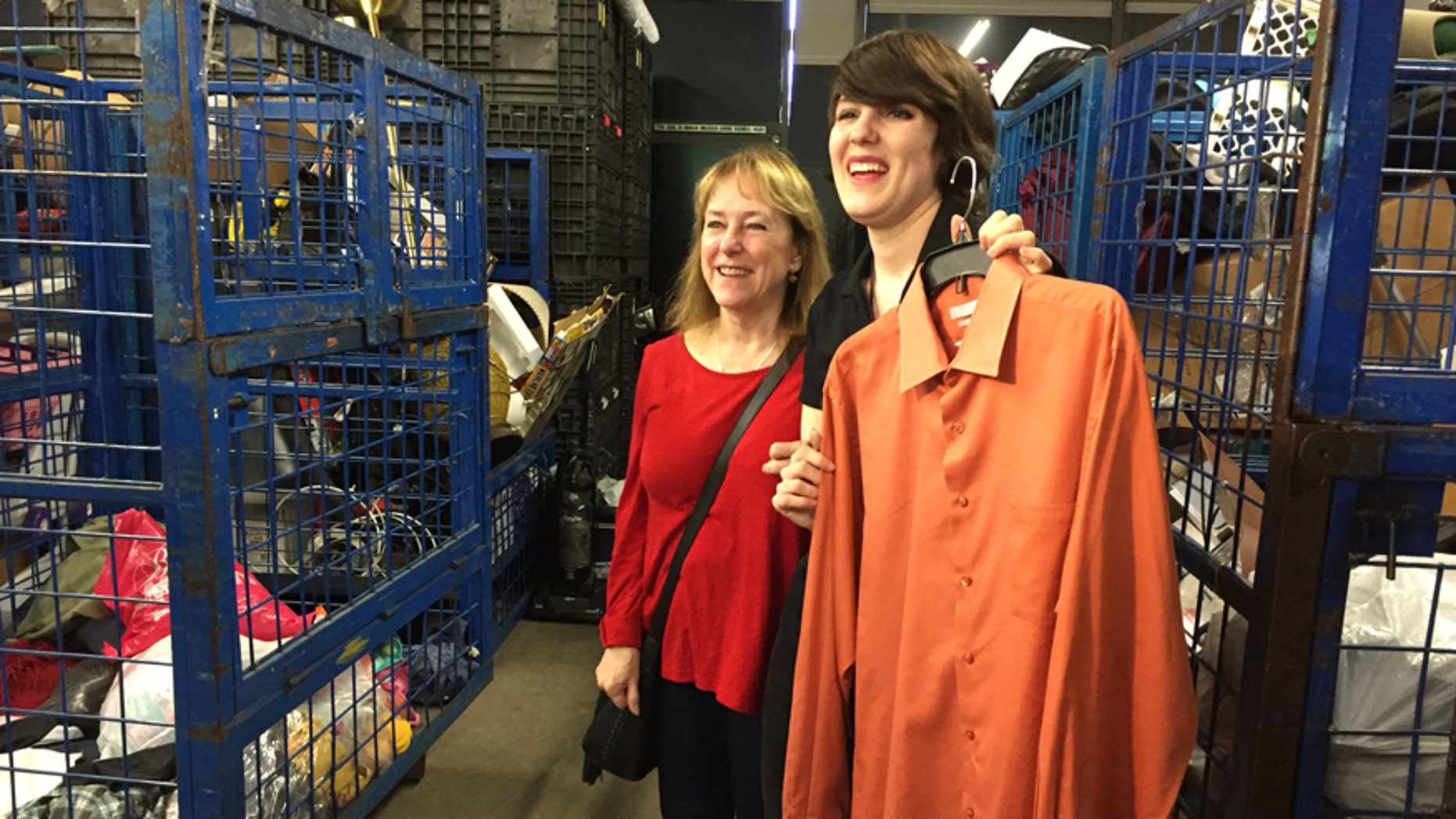 Linda Hoffmann (left) and Goodwill employee Caitlin Mulvihill with the shirt where Bob Hoffmann hid $8,000 in cash before it was accidentally donated.