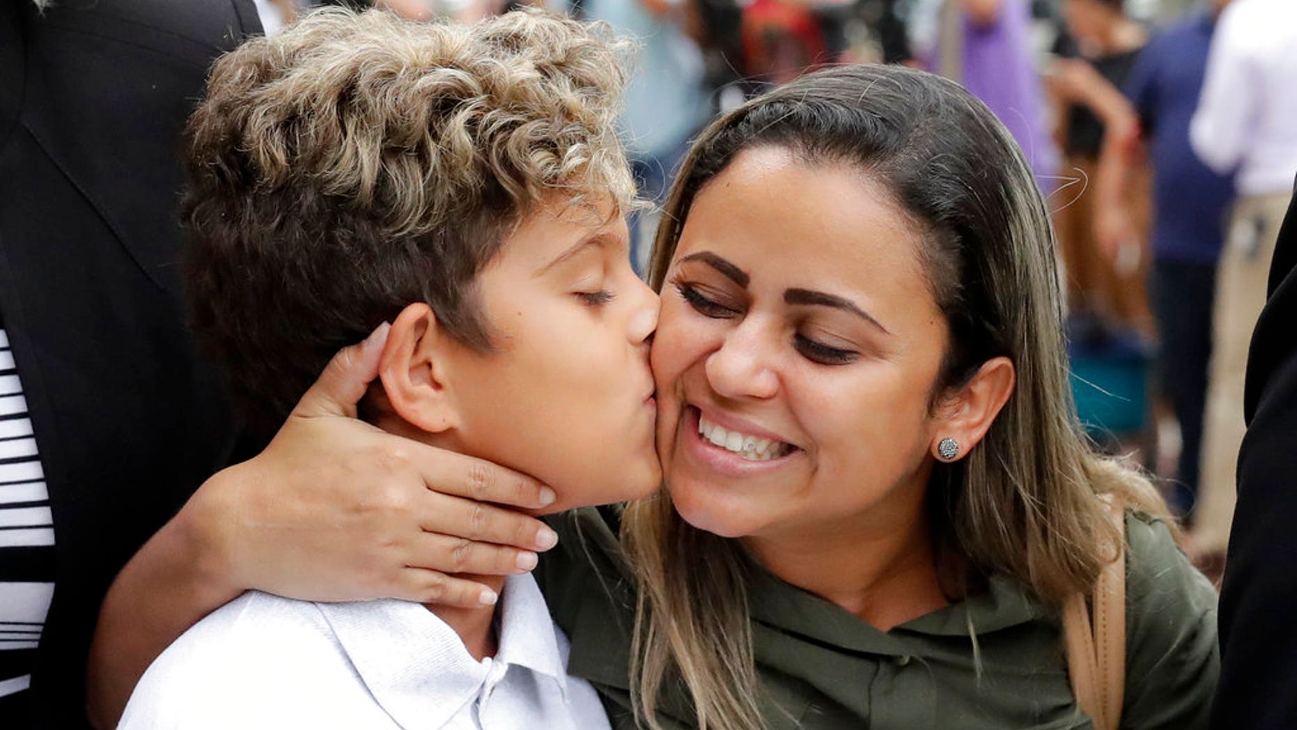 Diego Magalhaes, left, 10, kisses his mother Sirley Silveira, Paixao, an immigrant from Brazil seeking asylum with her son, after Diego was released from immigration detention, Thursday, July 5, 2018, in Chicago. (AP Photo/Charles Rex Arbogast)