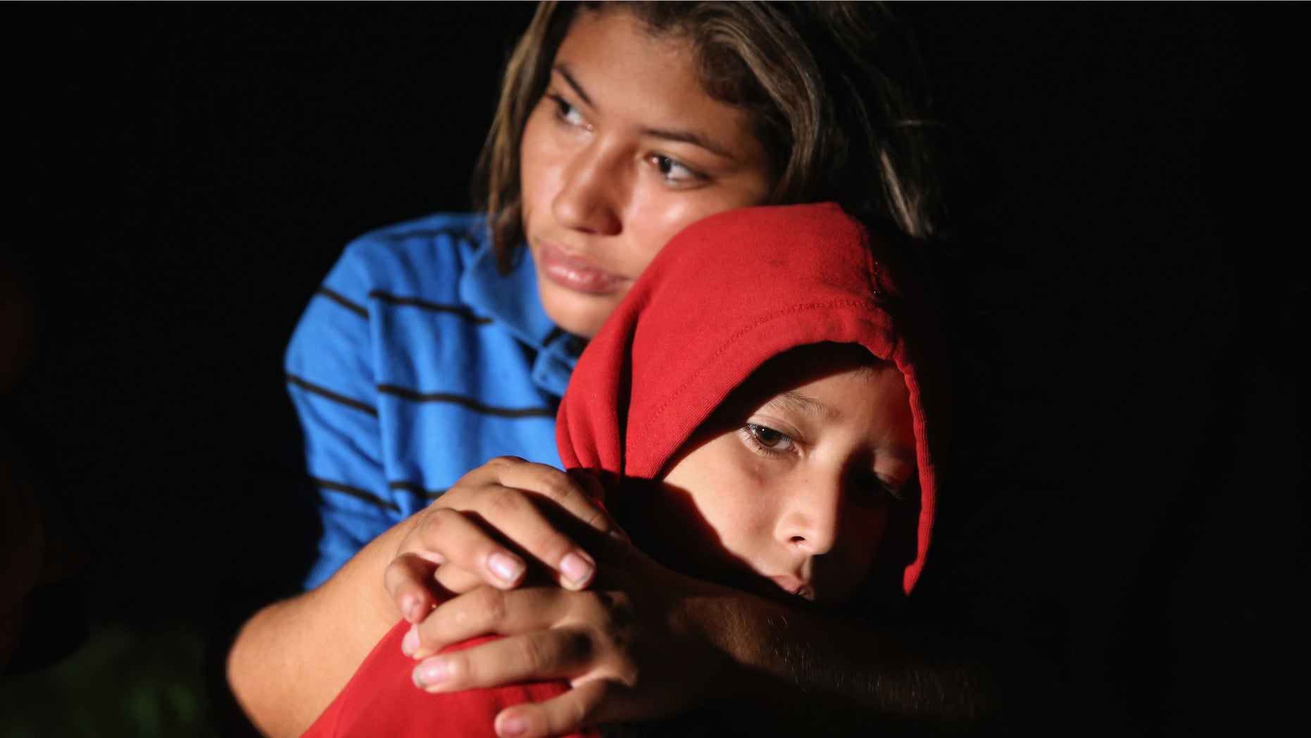 MISSION, TX - SEPTEMBER 08: Families of Central American immigrants, including Lorena Arriaga, 27, and her son Jason Ramirez, 7, from El Salvador, turn themselves in to U.S. Border Patrol agents after crossing the Rio Grande River from Mexico on September 8, 2014 to Mission, Texas. Although the numbers of such immigrant families and unaccompanied minors have decreased from a springtime high, thousands continue to cross in the border illegally into the United States. Texas' Rio Grande Valley sector is the busiest area for illegal border crossings, especially for Central Americans, into the U.S. (Photo by John Moore/Getty Images)