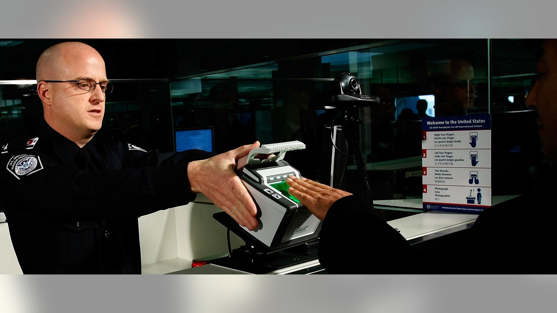 STERLING, VA - DECEMBER 10: International airline passengers are fingerprinted on all ten fingers by U.S. Customs and Border Protection officer Brian Pittack on arrival at Dulles International Airport December 10, 2007 in Sterling, Virginia. Digital fingerprints and photographs will now be collected from all non-U.S. citizens between the ages of 14 and 79 to check the collected data against joint FBI-DHS watchlist of criminals, immigration violators, and known or suspected terrorists. (Photo by Win McNamee/Getty Images)