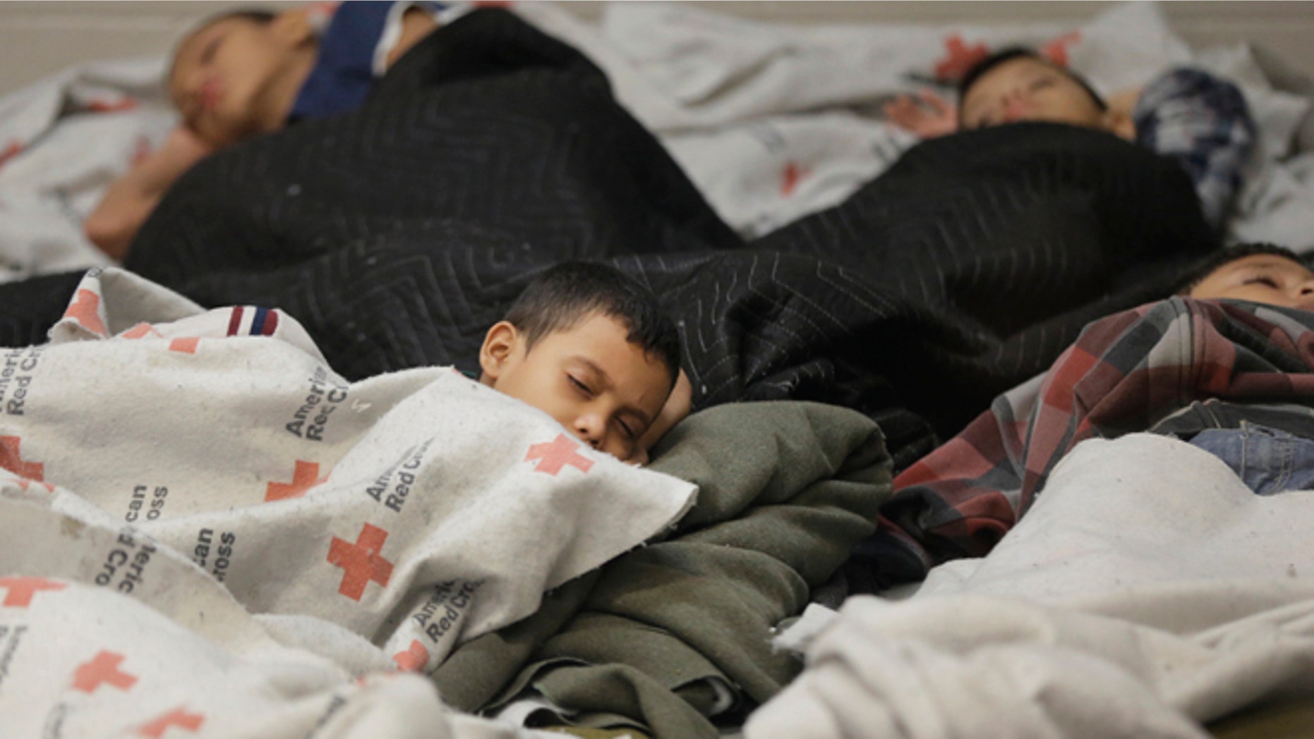 FILE - This June 18, 2014, file photo, detainees sleep in a holding cell at a U.S. Customs and Border Protection, processing facility in Brownsville,Texas. Immigration courts backlogged by years of staffing shortages and tougher enforcement face an even more daunting challenge since tens of thousands of Central Americans began arriving on the U.S. border fleeing violence back home. For years, children from Central America traveling alone and immigrants who prove they have a credible fear of returning home have been entitled to a hearing before an immigration judge. (AP Photo/Eric Gay, Pool, File)