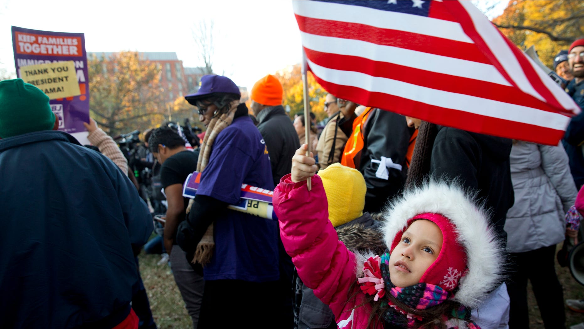 Nov. 21, 2014: Joselyn Vargas, 7, of Hyattsville, Md., waves a U.S. flag during a rally in Lafayette Park across from the White House in Washington