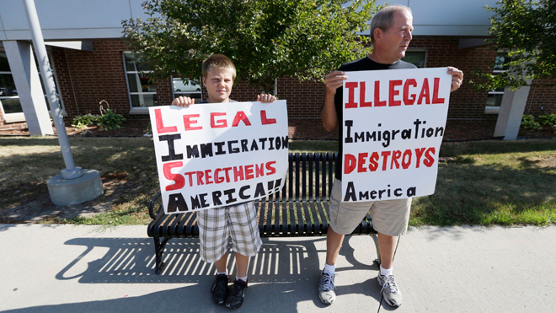 FILE: Aug. 2, 2013: Larry DeRocher, of Onawa, Iowa, right, and grandson Blake outside a forum on immigration held by Democratic Sens. Tom Harkin, Iowa, and Dick Durbin, Ill., in Ames, Iowa.