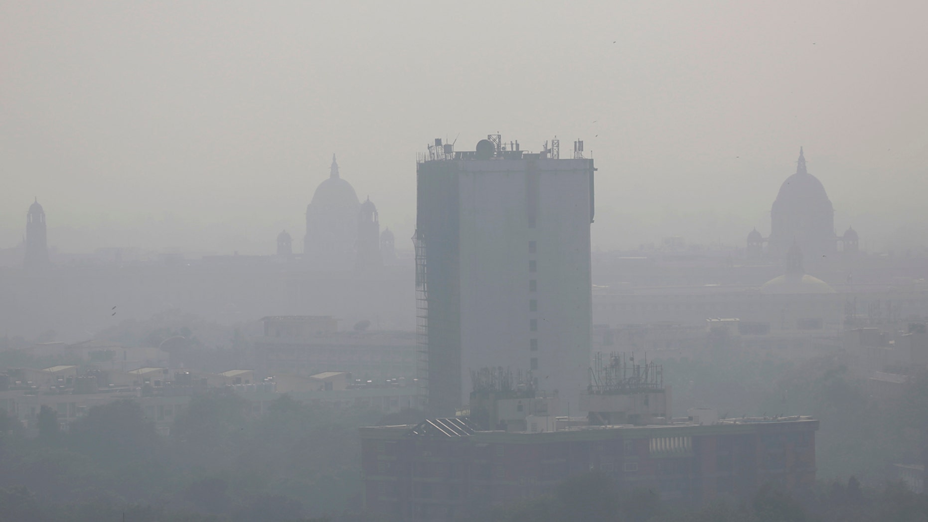 In this photo taken Friday, Oct. 28, 2016, a layer of smog envelops the city skyline before Diwali festival in New Delhi, India.