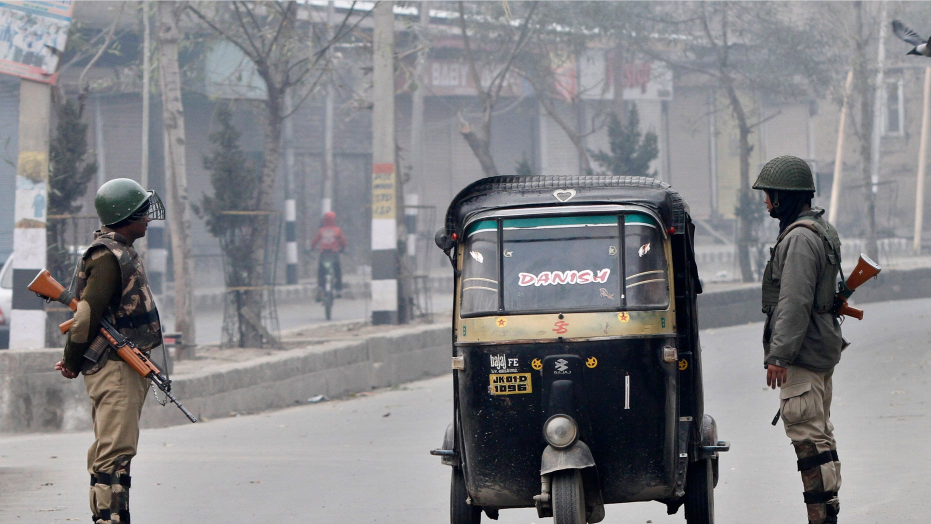 Indian paramilitary soldier interrogate civilians inside an autorickshaw at a temporary check point during curfew in Srinagar, India,