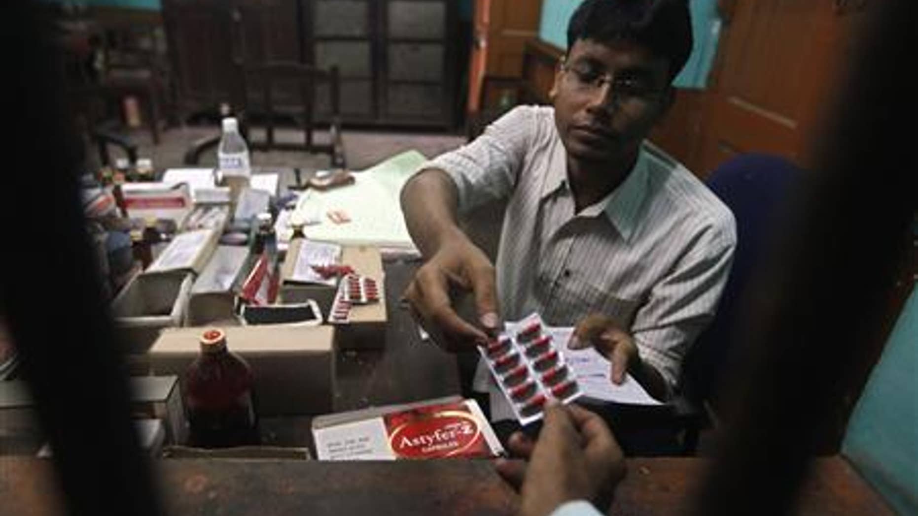 A pharmacist gives free medicine provided by the government, to a patient inside a government hospital in Kolkata July 3, 2012.