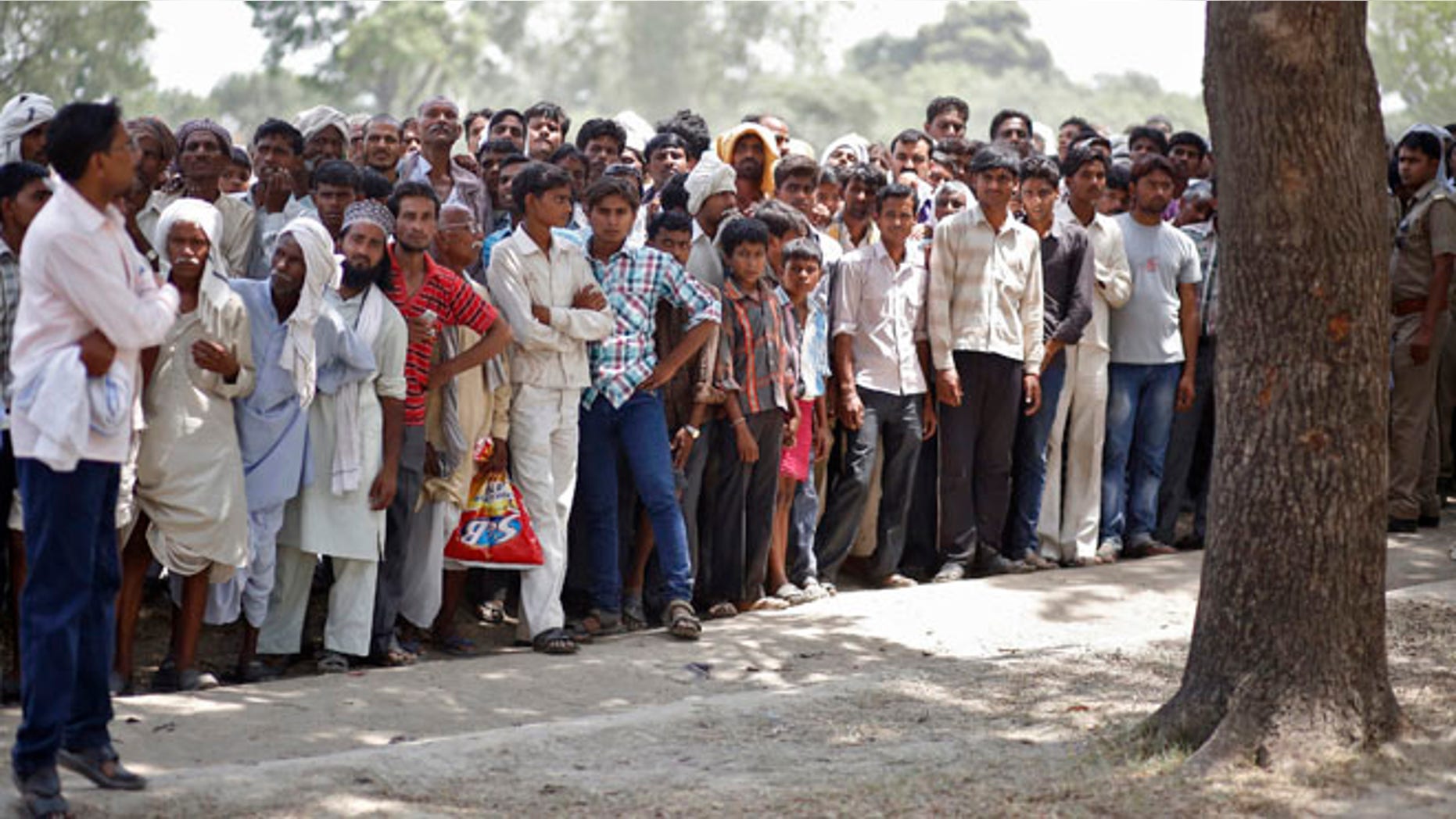 May 31, 2014: Onlookers stand at the site where two teenage girls, who were raped, were hanged from a tree in the northern Indian state of Uttar Pradesh.