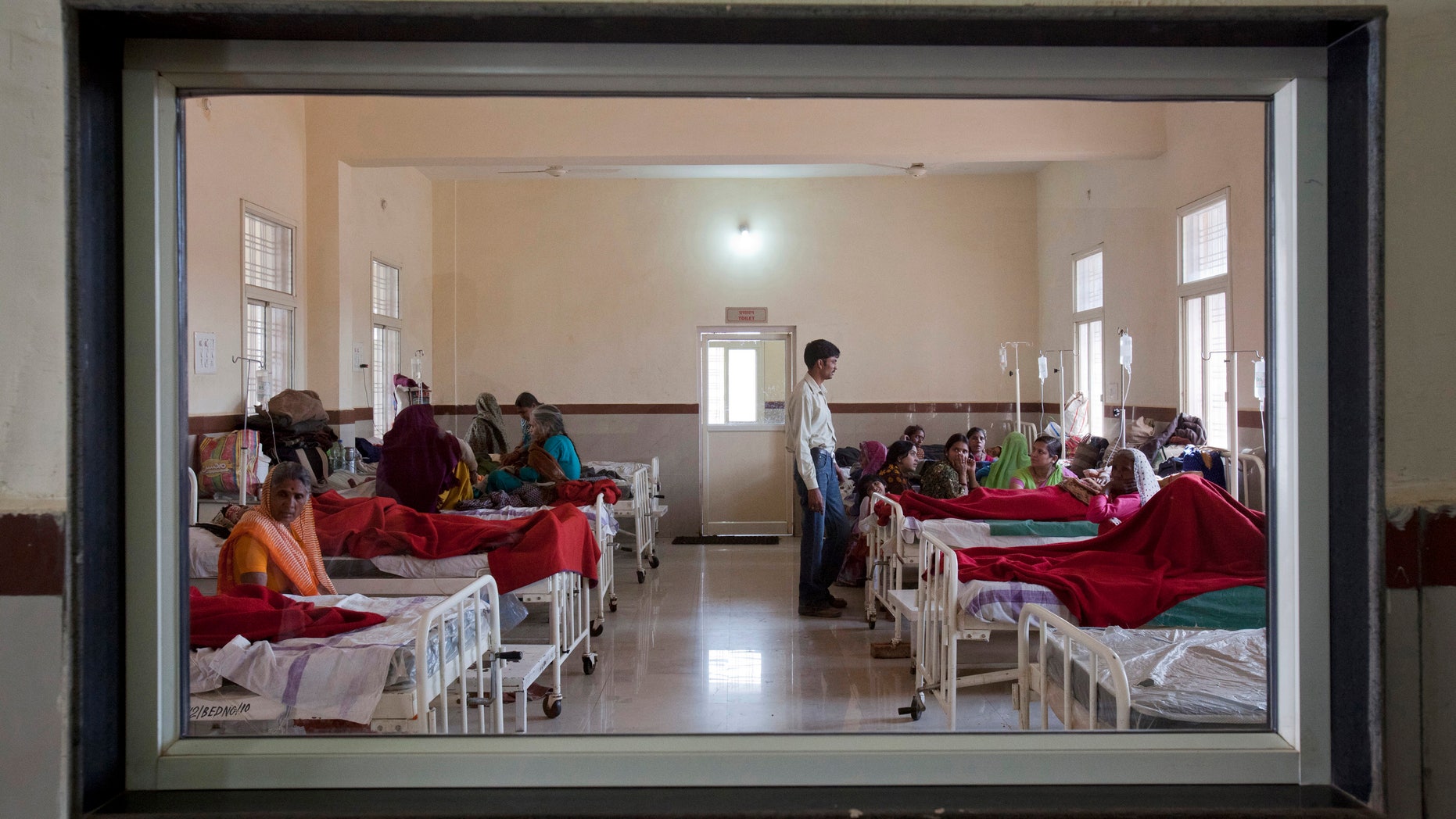 Women who have recently given birth and their relatives are pictured through a nurse';s observaton window as they rest in a post delivery ward at a district hospital in Shivpuri, in the central Indian state of Madhya Pradesh, February 25, 2012. REUTERS/Vivek Prakash