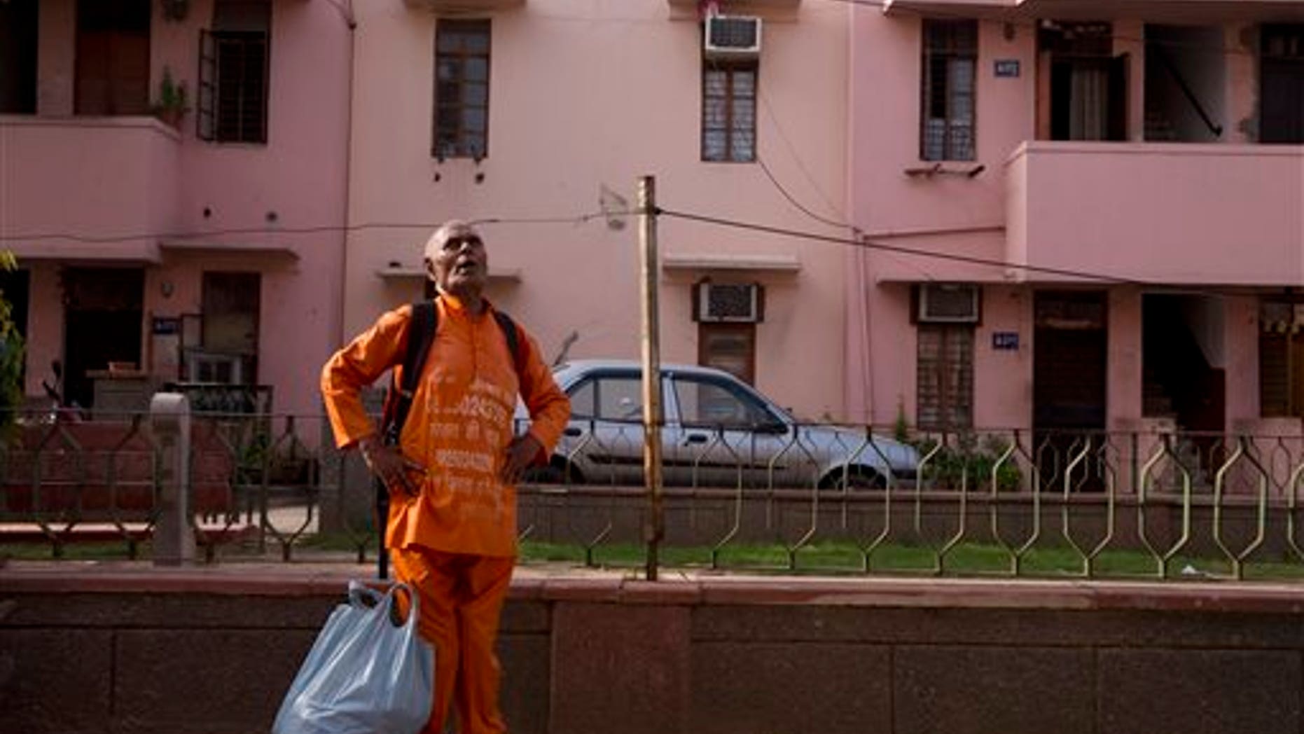 In this June 27, 2015 photo, Omkarnath, who goes by the name "Medicine Baba" calls out to people to donate unused medicines at a government colony in New Delhi, India. The chatty, 79-year-old retired blood-bank technician has been collecting unused prescription drugs from the affluent for the past eight years, and distributing whatever hasn't expired to patients who need medicines they cannot afford. (AP Photo/Saurabh Das)