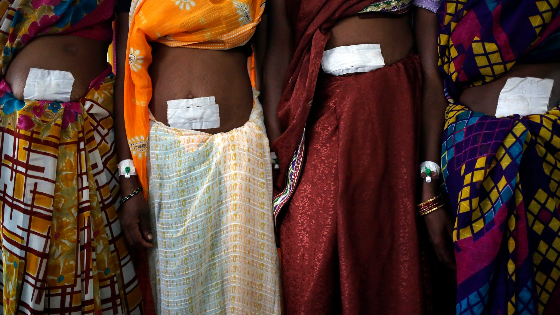 Women, who underwent sterilization surgery at a government mass sterilisation camp, pose for pictures inside a hospital at Bilaspur district in the eastern Indian state of Chhattisgarh November 14, 2014. The doctor whose sterilisation of 83 women in less than three hours ended in at least a dozen deaths said the express operations were his moral responsibility and blamed adulterated medicines for the tragedy. REUTERS/Anindito Mukherjee