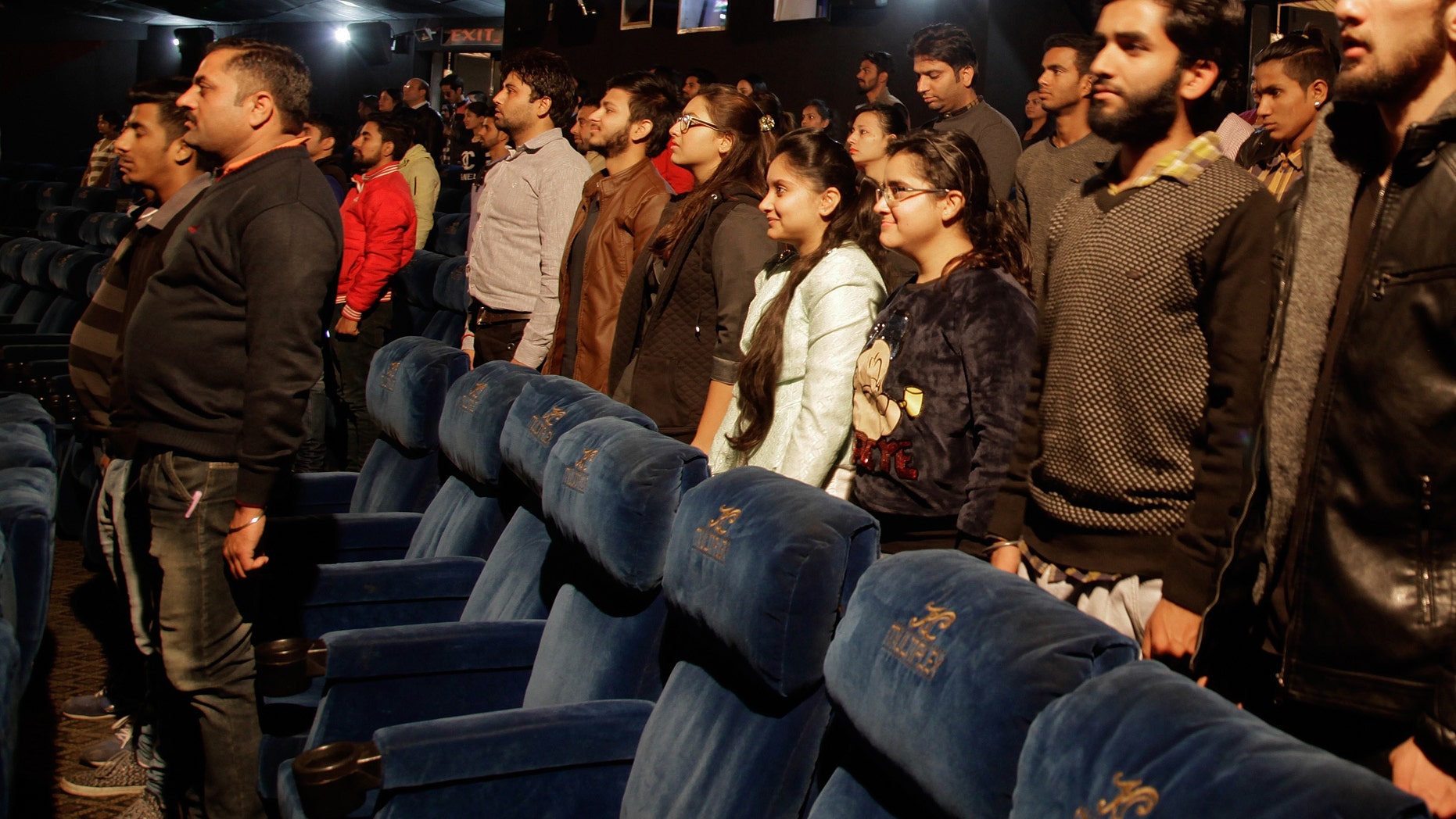 Indian movie goers stand up as national anthem is played at a movie hall before the screening of a movie in Jammu, India, Tuesday, Dec. 13, 2016. A ruling by India's Supreme Court last month said that the anthem must be played before every film screening in the country and that audiences must stand. The court said the rule was aimed at instilling a sense of patriotism. (AP Photo/Channi Anand)