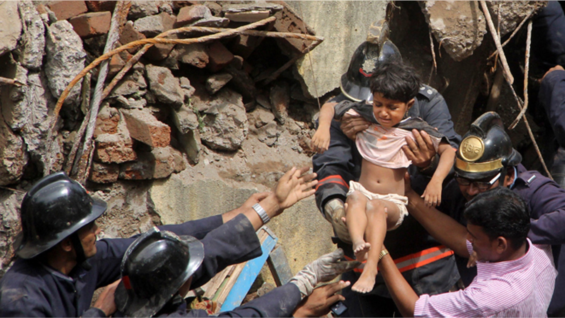 Sept. 27, 2013: Indian Fire officials rescue a girl from debris of a collapsed building in Mumbai, India. The multi-story residential building collapsed in India's financial capital of Mumbai early Friday, killing at least three people and sending rescuers racing to reach dozens of people feared trapped in the rubble. (AP Photo)