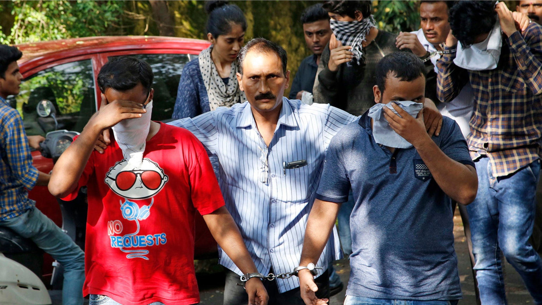 Oct. 6, 2016: A police official, center, escorts two men outside the court in Thane, on the outskirts of Mumbai, India.