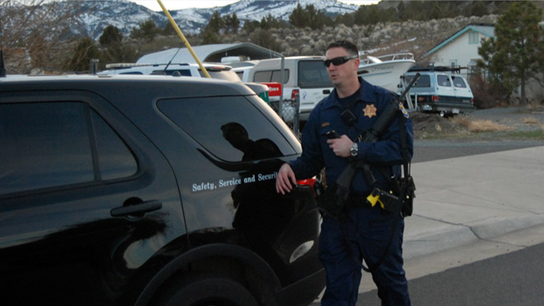 An unidentified California Highway Patrolman leaves the home of former Cedarville Rancheria chairwoman Cherie Lash Rhoades on Friday, Feb. 21, 2014 in Cedarville, Calif., where police served a search warrant. Rhoades is being held on suspicion she killed four people and wounded two others at a tribal meeting in Alturas, Calif., held to consider her eviction. (AP Photo/Jeff Barnard)