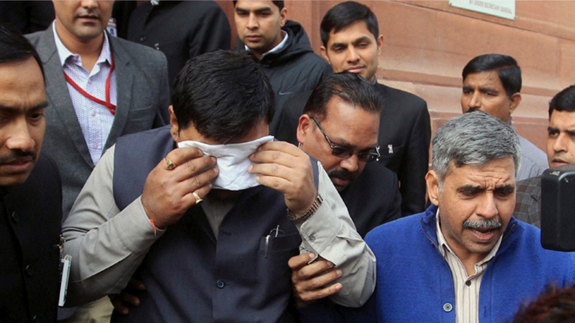 Feb. 13, 2014: An unidentified member of India's parliament covers his face with a handkerchief after being affected by pepper spray gas in New Delhi, India.