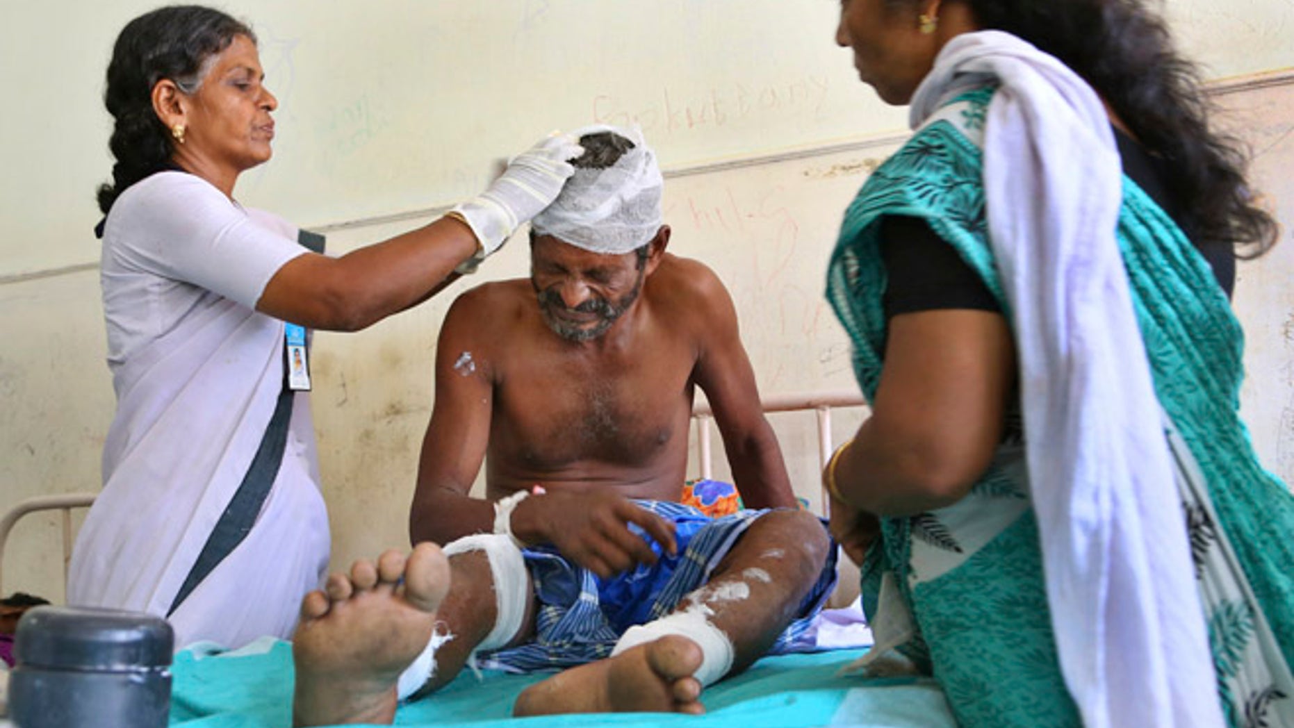 April 11: A victim grimaces in pain as he receives treatment at Kollam district hospital a day after he was injured after a massive fire broke out during a fireworks display at the Puttingal temple complex in Paravoor village, Kollam district, southern Kerala state, India.