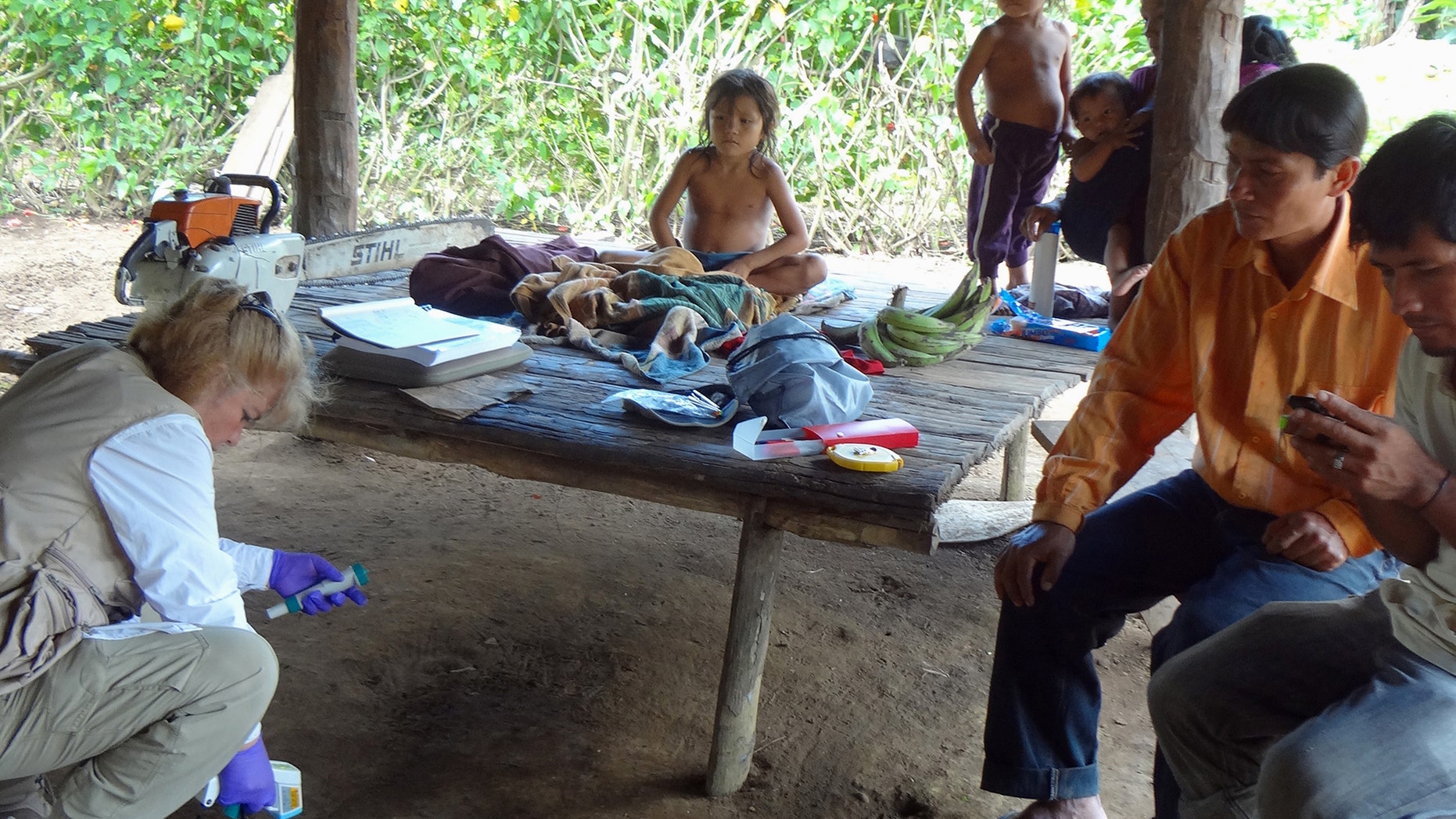 In this photo provided by Science Advances shows microbiologist Maria Gloria Dominguez-Bello, collecting temperature information of the floor at one of the Checherta huts. Whether it's a jungle hut or a high-rise apartment, your home is covered in bacteria, and new research from the Amazon suggests city dwellers might want to open a window. (Humberto Cavallin/ University of Puerto Rico/Science Advance via AP)