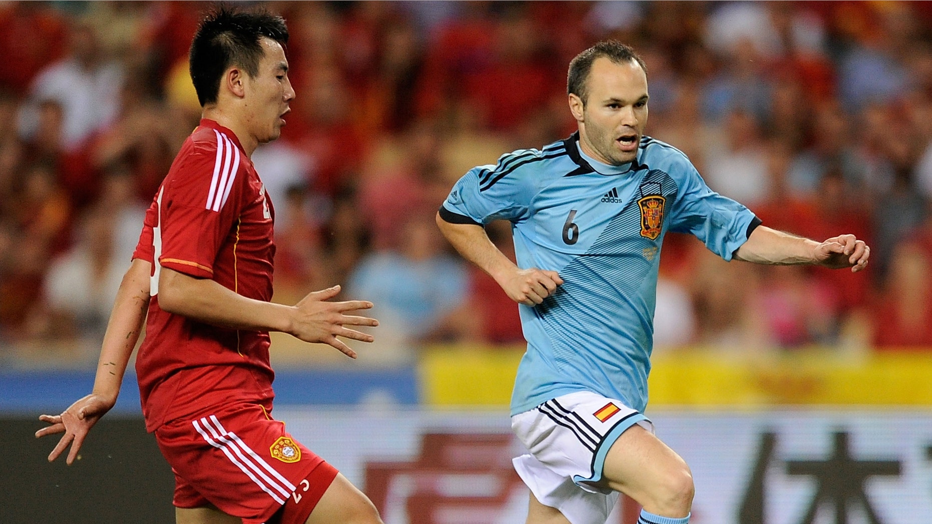 SEVILLE, SPAIN - JUNE 03: Andres Iniesta (R) of Spain dribbles the ball past Quin Sheng of China during the International Friendly match between Spain and China at La Cartuja stadium on June 3, 2012 in Seville, Spain. (Photo by Denis Doyle/Getty Images)