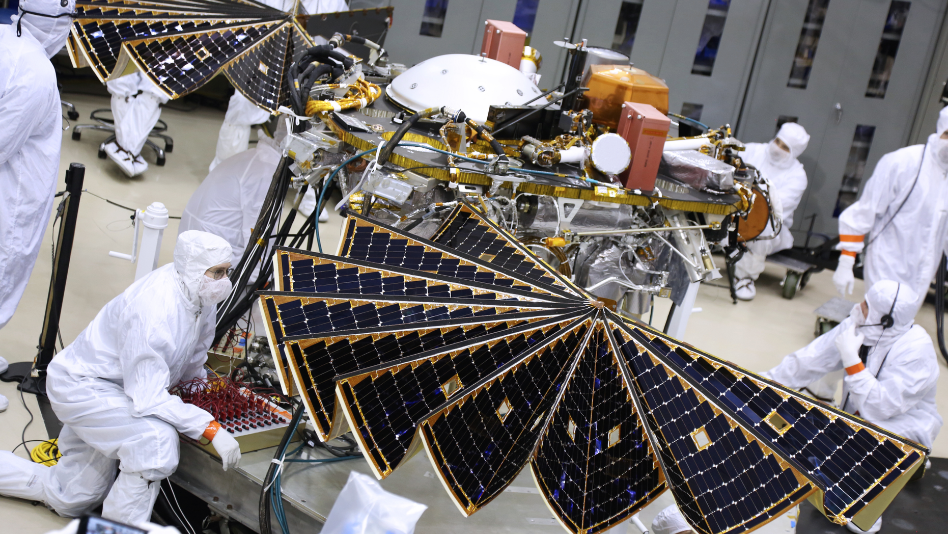 Technicians unfurl the InSight Mars lander's solar arrays during a key test at a Lockheed Martin Space Systems facility in Colorado on Jan. 23, 2018.
