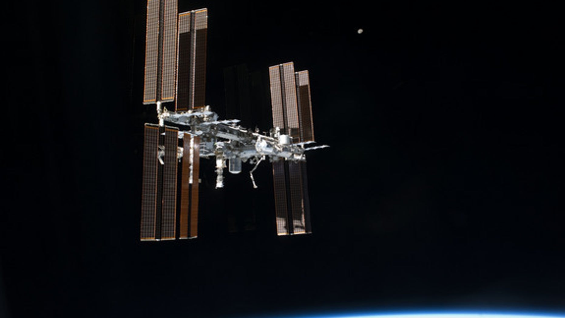 This picture of the International Space Station and the moon was photographed from the space shuttle Atlantis just after the two spacecraft undocked on July 19, 2011, during NASA's final shuttle mission STS-135.