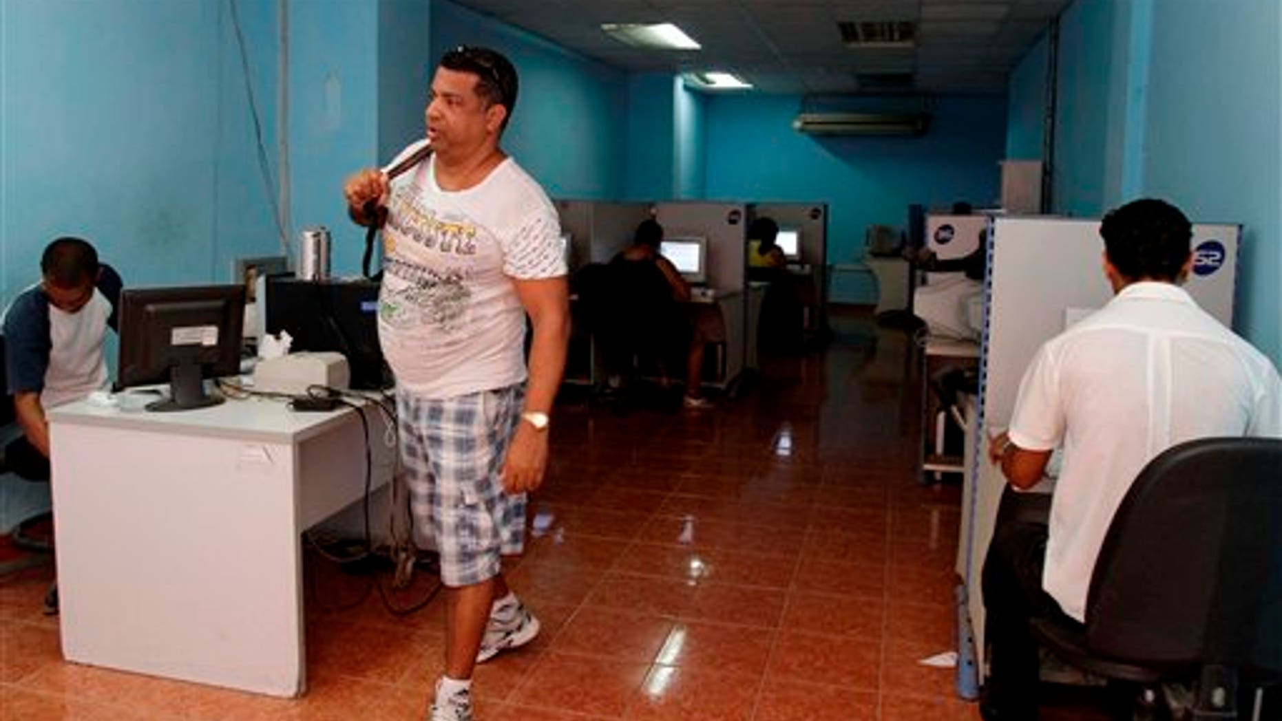 In this May 9, 2012 photo, a man leaves a state-run computer center in Havana, Cuba. Cuban officials welcomed the arrival of an undersea fiber-optic cable linking the country to Venezuela, which was supposed to boost web capacity 3,000-fold. Even a retired Fidel Castro had hailed the dawn of a new cyber-age on the island. More than a year later, the government barely speaks of the cable anymore and Cuba's internet connection is still the slowest in the hemisphere. (AP Photo/Franklin Reyes)
