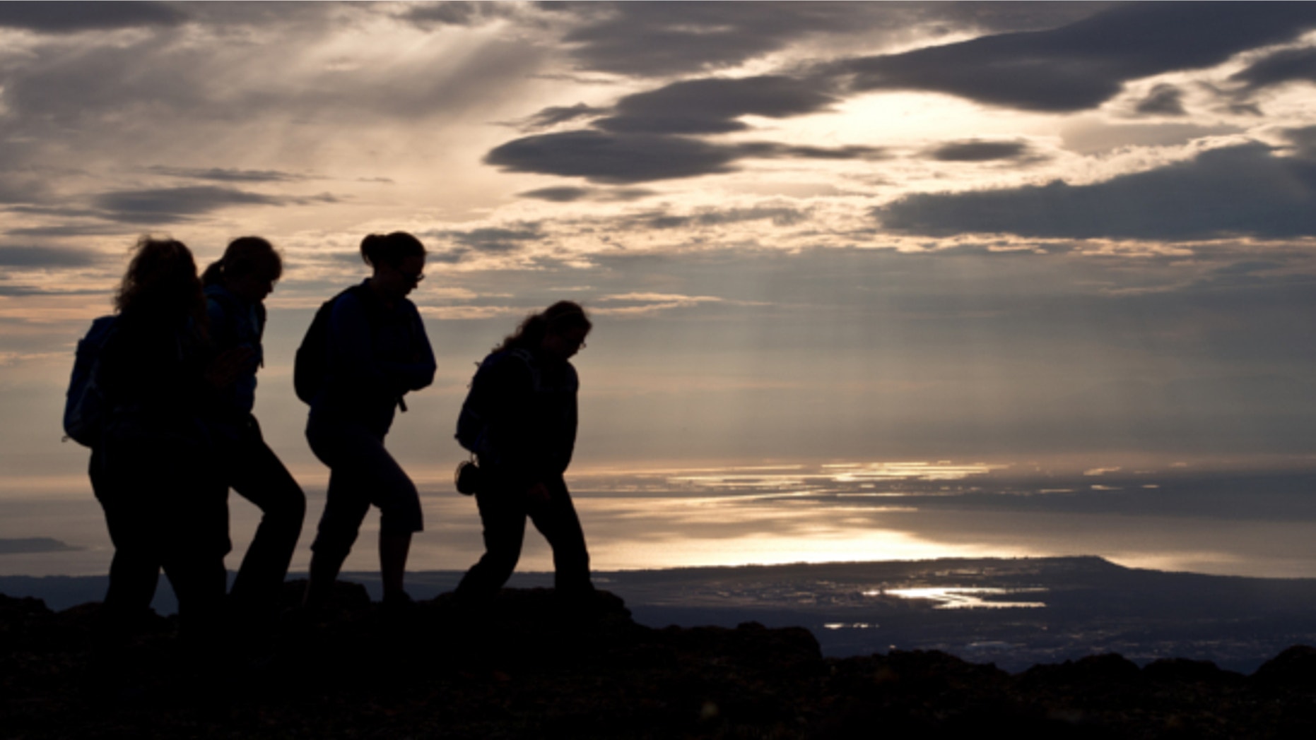 June 20, 2013: Hikers take in the view of Anchorage, Alaska, on the evening of summer solstice.