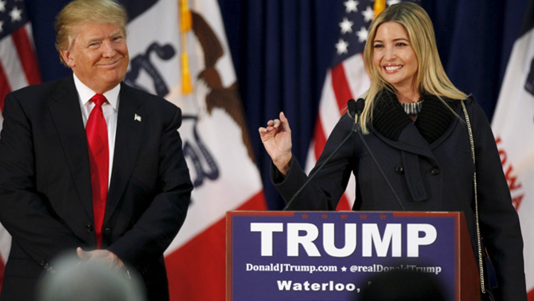 U.S. Republican presidential candidate Donald Trump listens as his daughter Ivanka speaks at a campaign rally on caucus day in Waterloo, Iowa February 1, 2016. REUTERS/Rick Wilking - RTX24YNA