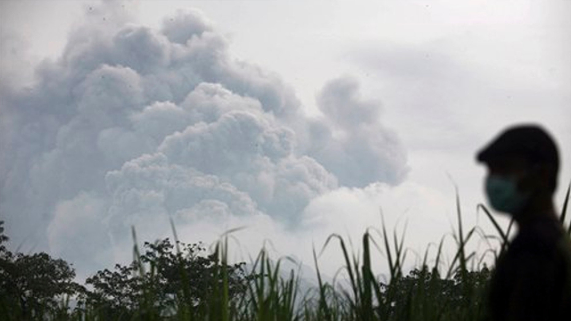 Feb. 14, 2014: A man watches from Mbaladak village in Blitar, East Java, Indonesia, as Mount Kelud erupts.