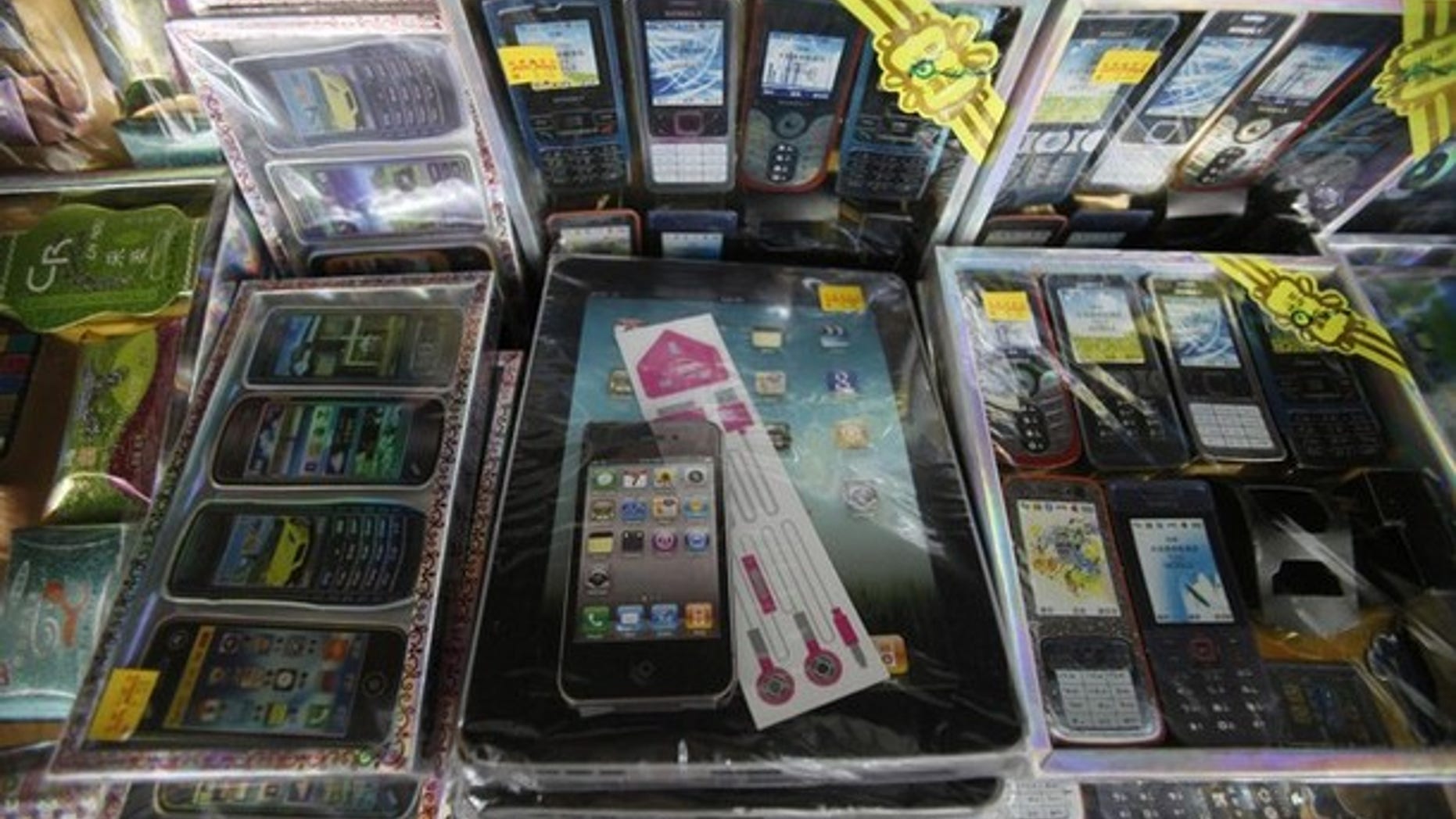 Paper replicas of first generation iPads and iPhones sit on a shelf among other electronic gadgets for sale for the Chinese Qingming festival or Ancestors Day at a prayer supplies shop in Petaling Jaya outside Kuala Lumpur.