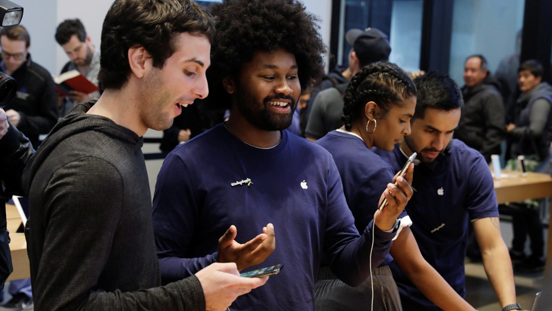 File photo: An Apple sales associate speaks with a customer waiting to purchase a new iPhone X in New York, U.S., November 3, 2017. (REUTERS/Lucas Jackson)