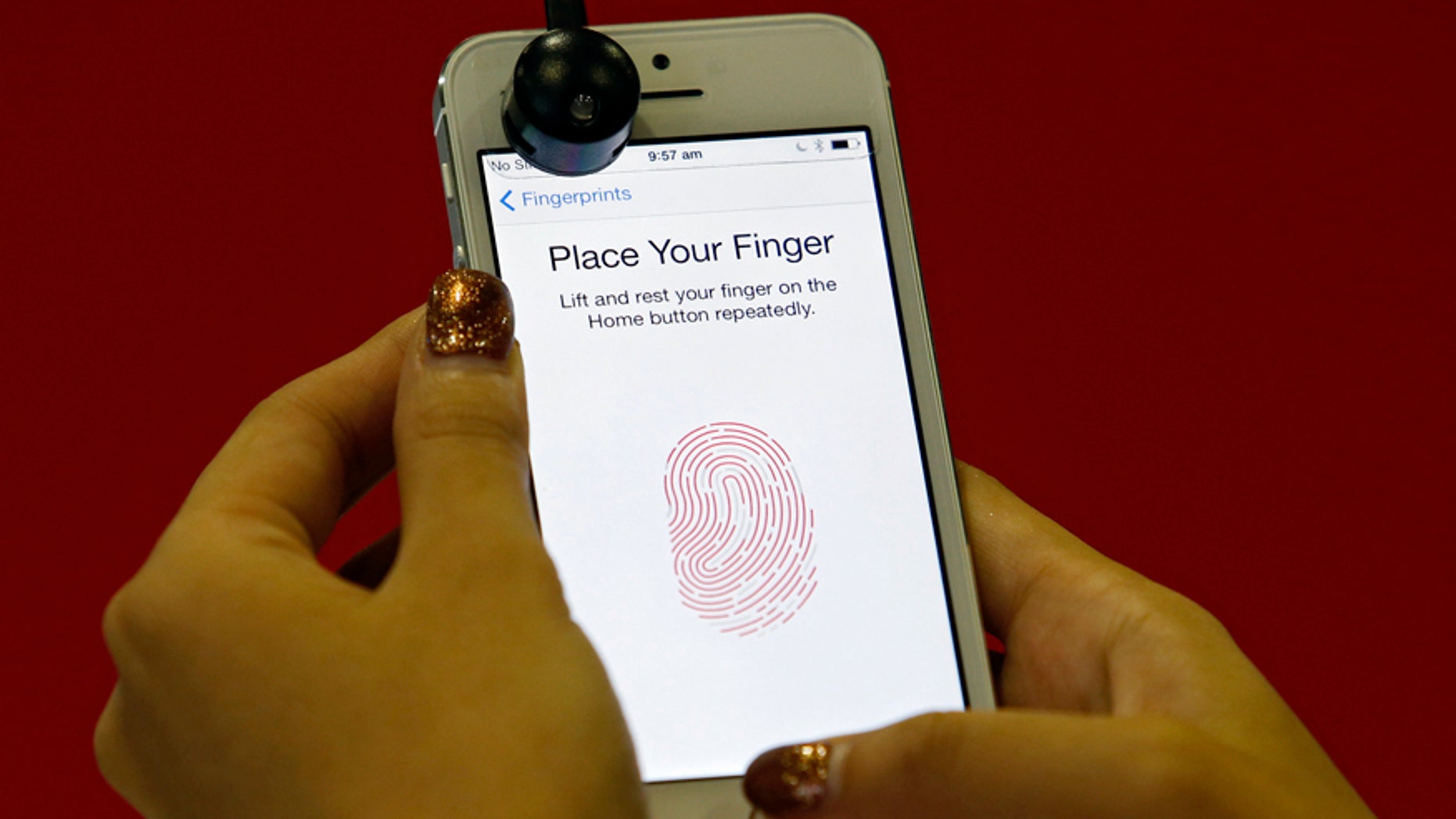 A promoter demonstrates the fingerprint scanner feature of the newly launched Apple iPhone 5S in Singapore September 20, 2013. REUTERS/Edgar Su (SINGAPORE - Tags: SCIENCE TECHNOLOGY BUSINESS TELECOMS) - RTX13RZQ