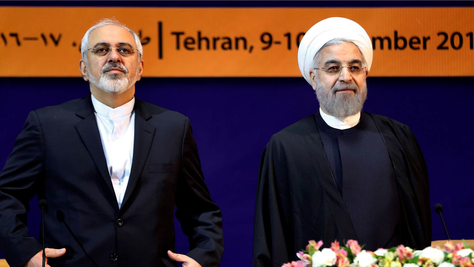 Dec. 9, 2014: Iranian President Hassan Rouhani, right, and Foreign Minister Mohammad Javad Zarif listen to the Iranian national anthem ahead of the "World Against Violence and Extremism," conference.