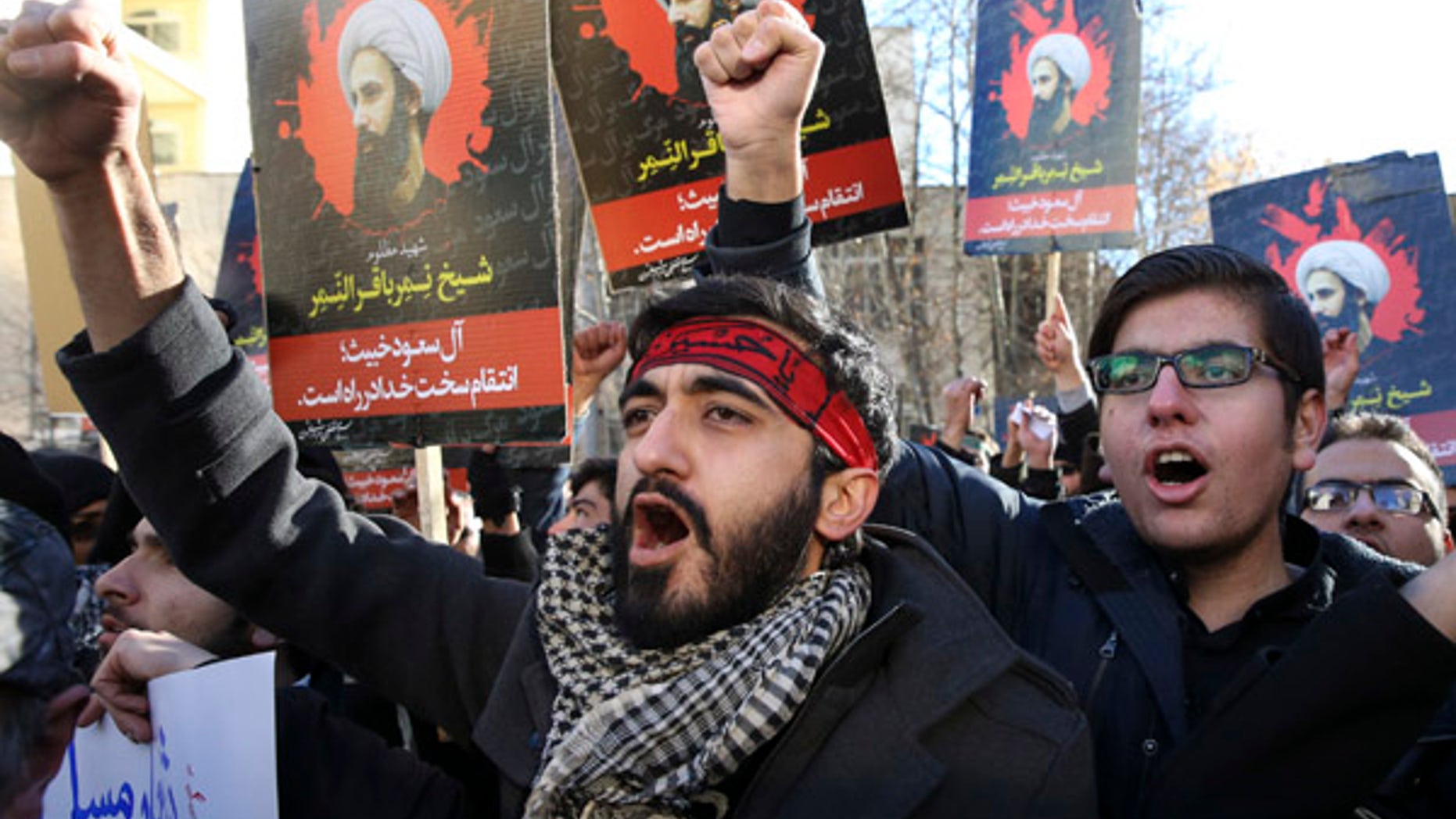 Iranian demonstrators chant slogans during a protest denouncing the execution of Sheikh Nimr al-Nimr, a prominent opposition Shiite cleric in Saudi Arabia, seen in posters, in front of the Saudi Embassy, in Tehran, Sunday, Jan. 3, 2016. Saudi Arabia announced the execution of al-Nimr on Saturday along with 46 others. His execution drew condemnation from Shiites across the region. (AP Photo/Vahid Salemi)