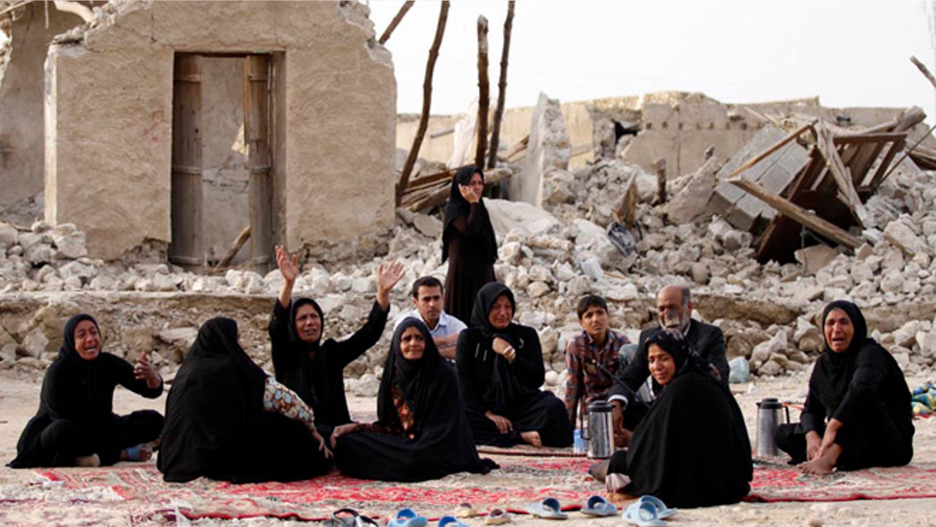 April 10, 2013: Survivors mourn for their loved ones who were killed in Tuesday's earthquake in front of the ruins of their houses, at the city of Shonbeh, southern Iran. A 6.1 magnitude earthquake killed dozens and injured hundreds more in a sparsely populated area in southern Iran on Tuesday, Iranian officials said, adding that it did not damage a nuclear plant in the region.