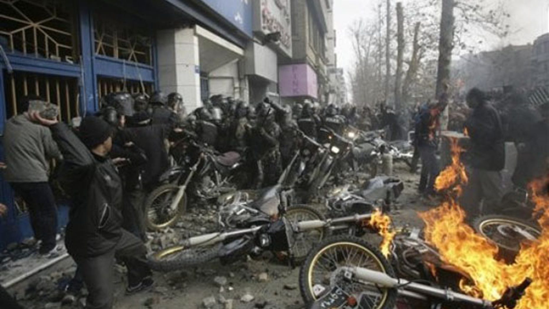 This photo, taken by an individual not employed by the Associated Press and obtained by the AP outside Iran, shows an Iranian protester, left, throwing a rock at police officers in Tehran Dec. 27. (AP Photo)