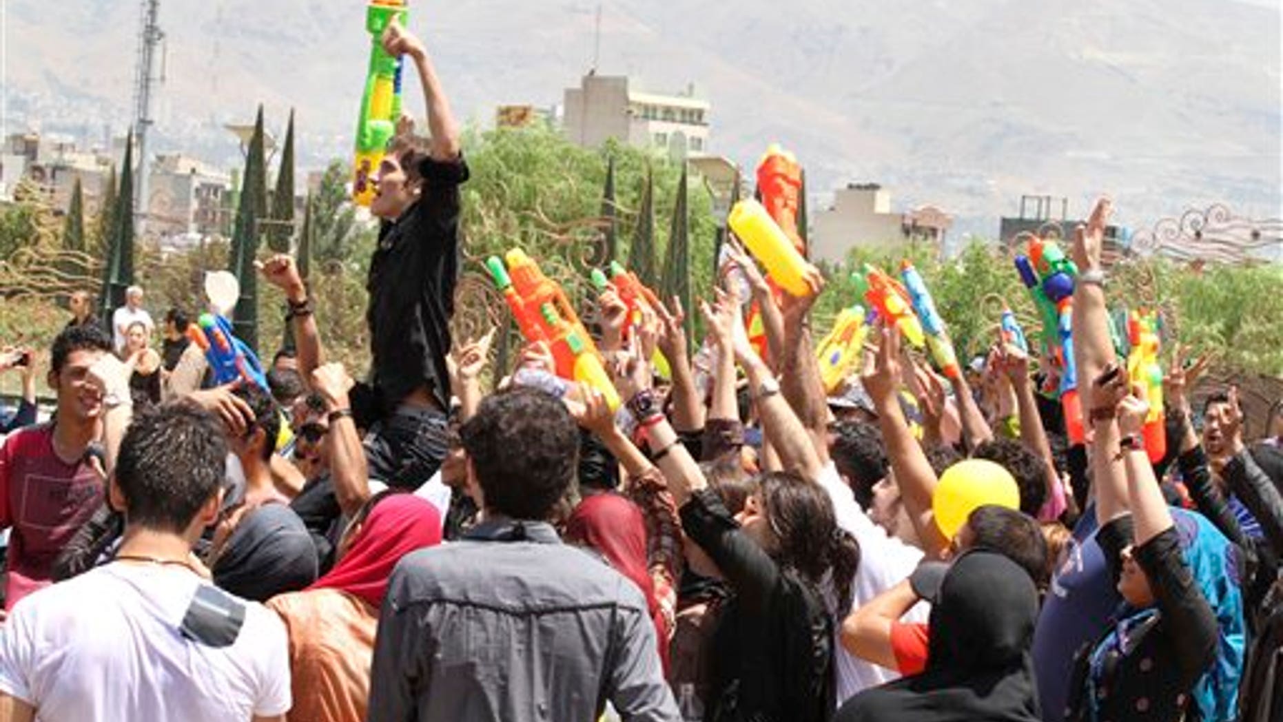 In this picture taken on Friday, July 29, Iranian youths celebrate with their water guns, during their water fights at the Water and Fire Park in northern Tehran, Iran. Iran is trying to put down a new wave of civil disobedience - flash mobs of young people who break into boisterous fights with water guns in public parks.