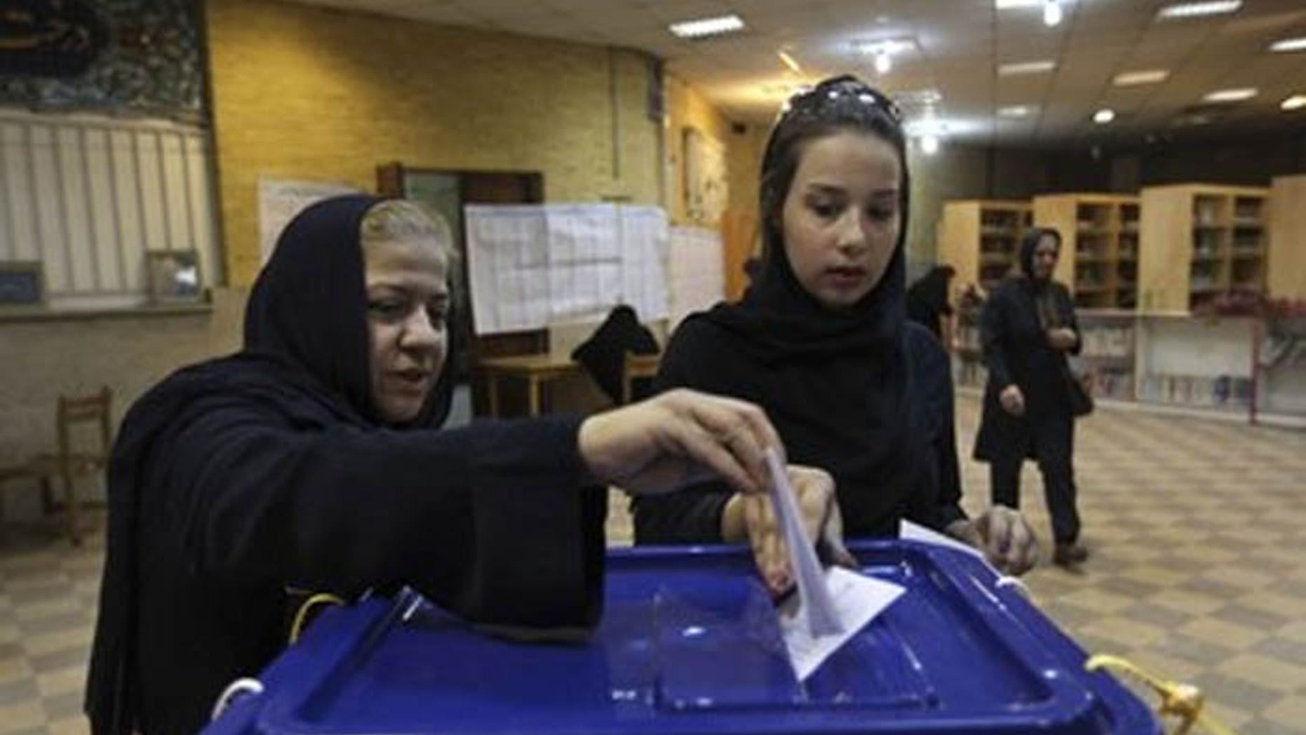 Although these two women are casting their votes for president in Tehran, thousands of Iranians around the world, including in the U.S., will also fill out ballots. (AP)