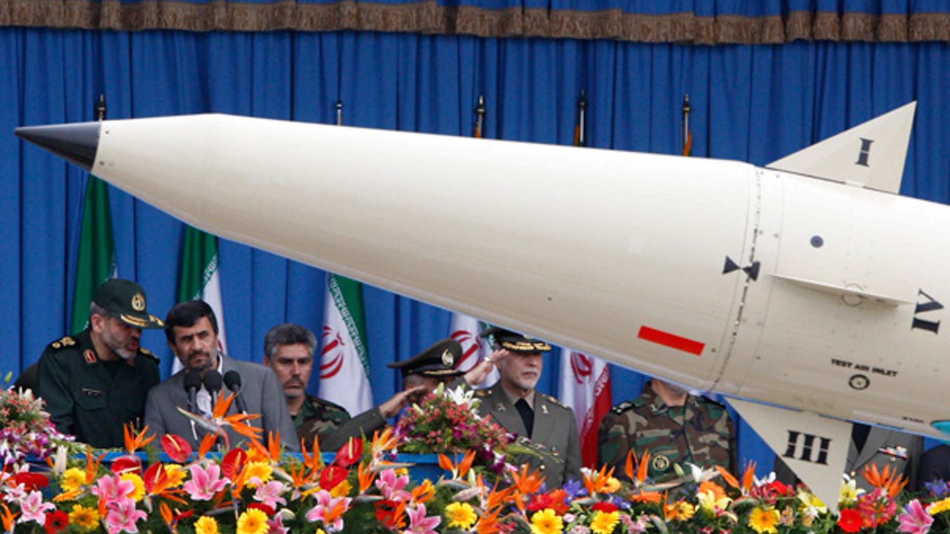 April 18: Iranian President Mahmoud Ahmadinejad, second left, listens to his Defense Minister, Gen. Ahmad Vahidi, as a rocket is paraded during National Army Day.