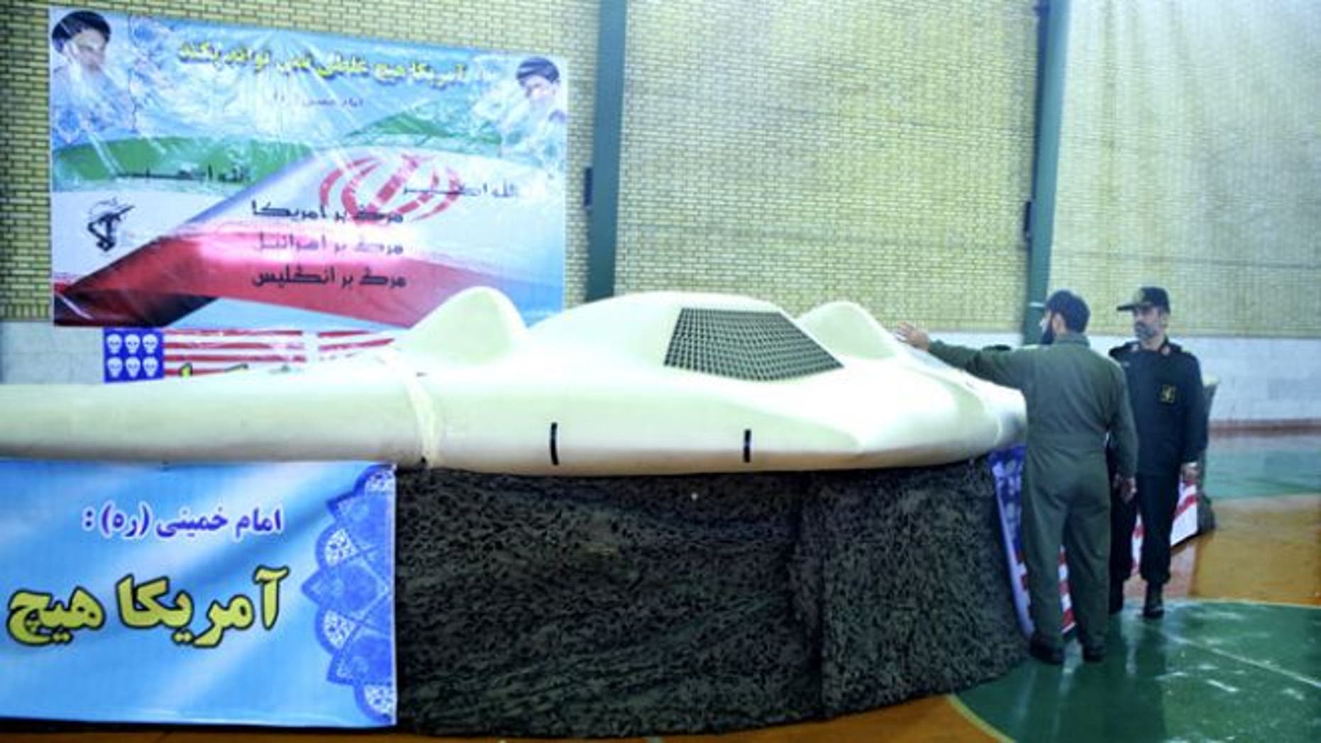 Dec. 8, 2011: A photo by the Iranian Revolutionary Guards purportedly shows a U.S. RQ-170 Sentinel drone that Tehran says its forces downed earlier in the week, as the chief of the aerospace division of Iran's Revolutionary Guards, Gen. Amir Ali Hajizadeh, right, listens to an unidentified colonel.