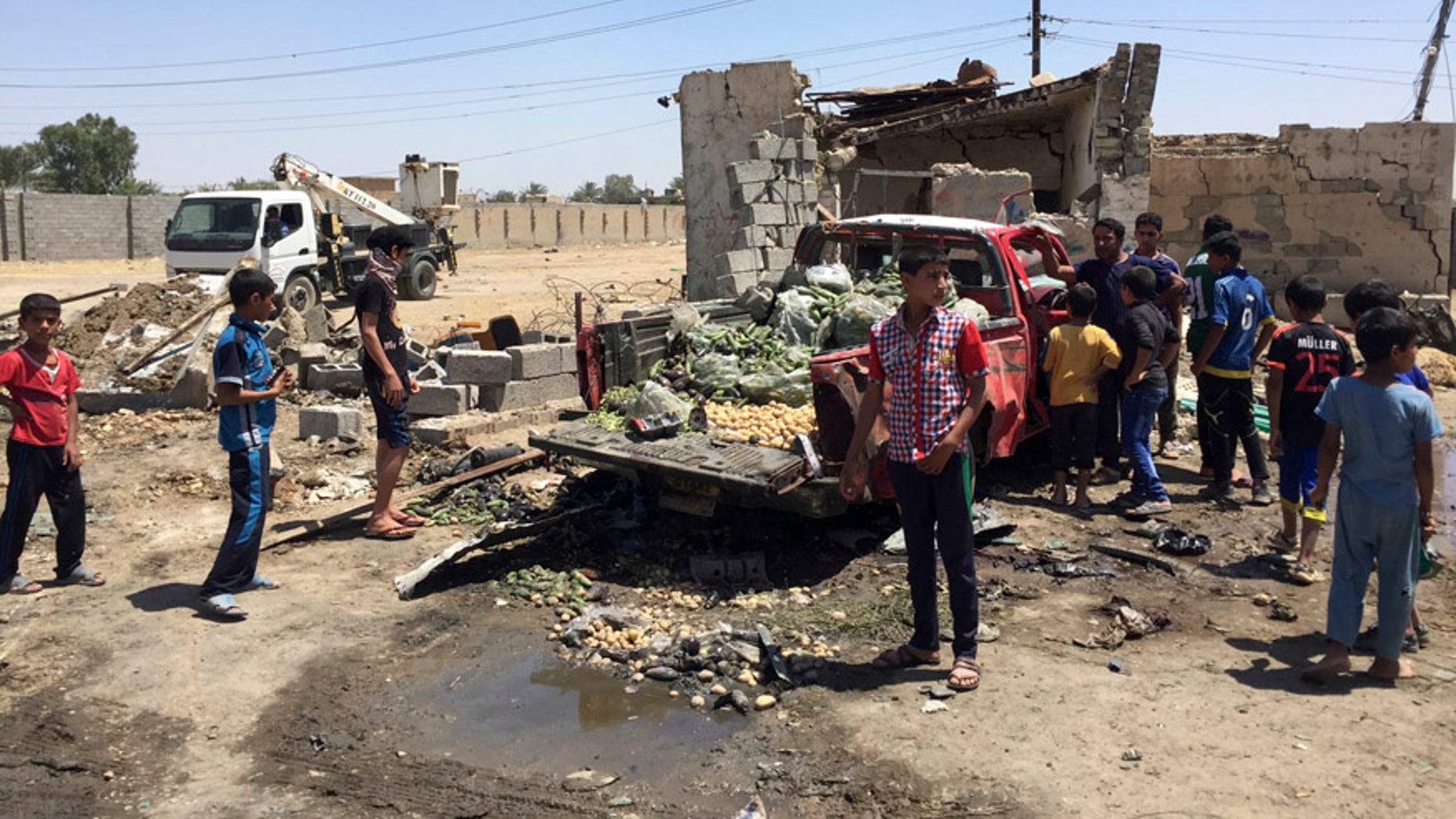 April 30, 2016: Civilians inspect the scene of car bombing at an open-air market selling fruit, vegetables and meat in Baghdad's southeast suburb of Nahrawan, Iraq.