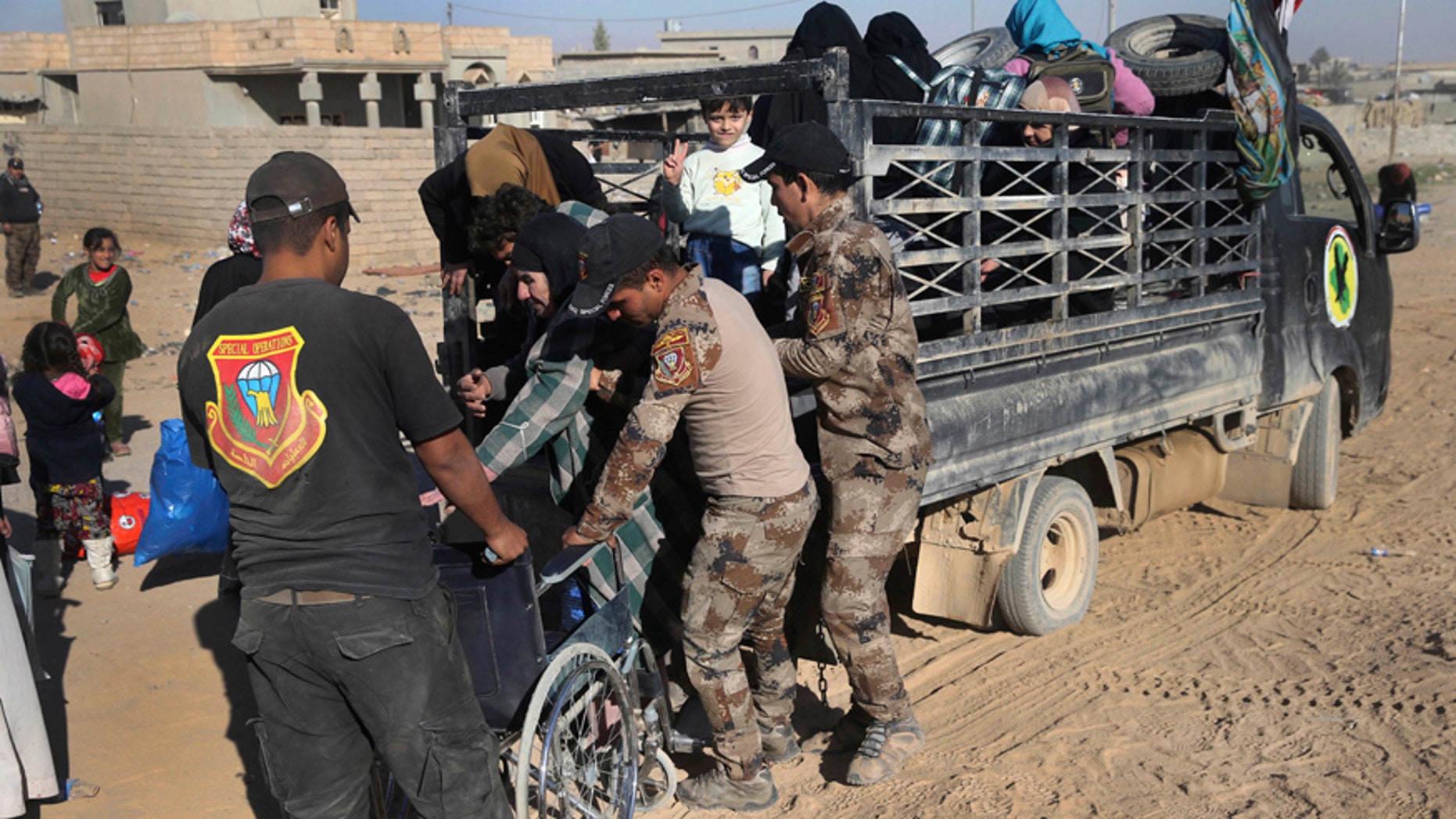Nov. 23, 2016: Iraqi special forces soldiers help a handicapped woman, center, fleeing with her family the fighting between the Islamic State militants and Iraqi forces, in the Al-Samah neighborhood, in Mosul, Iraq.