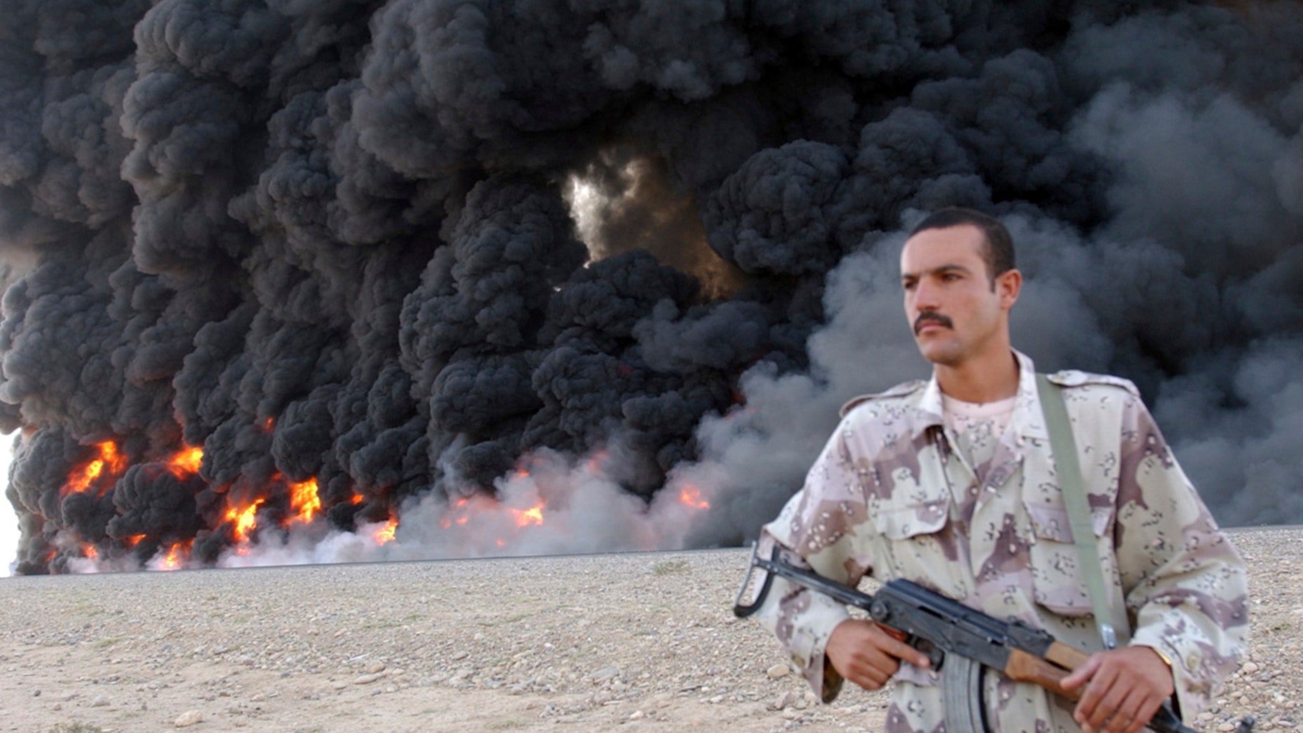 In this Sept. 13, 2005, file photo, an Iraqi soldier secures a burning pipeline near Kirkuk, 290 kilometers (180 miles) north of Baghdad, Iraq.