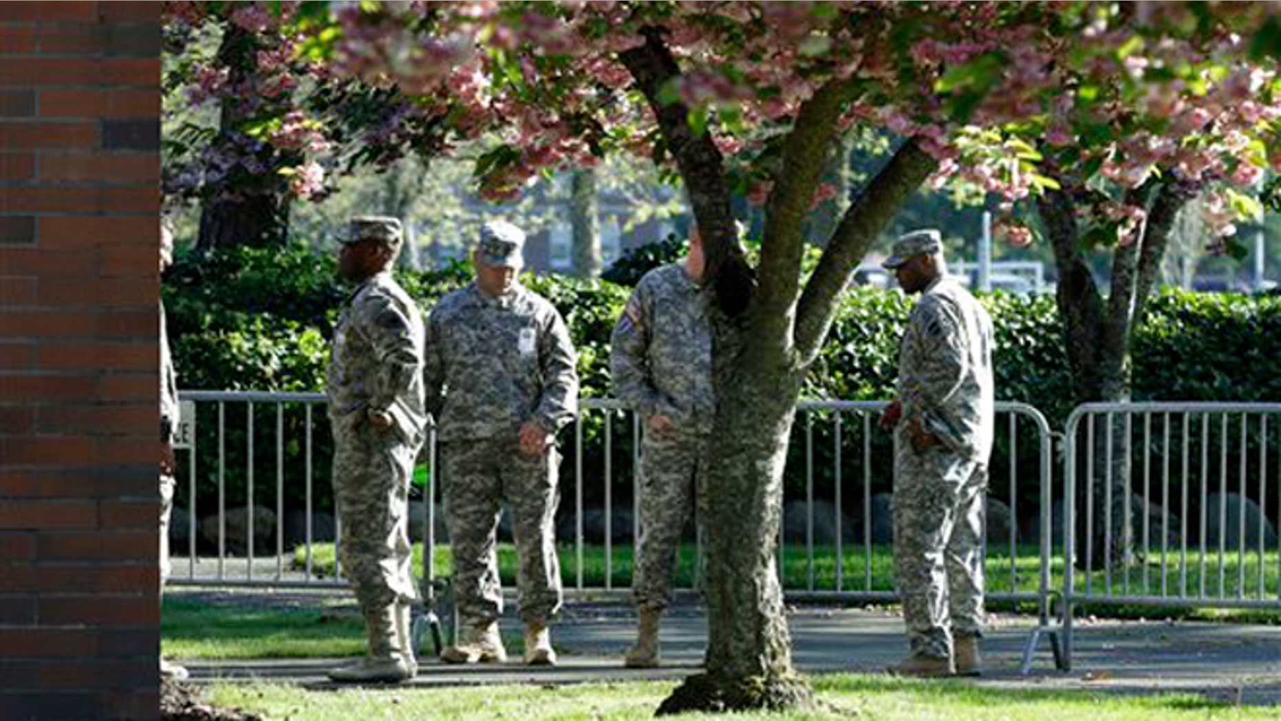 Soldiers assisting with communications and security tasks stand outside the building at Joint Base Lewis-McChord, Wash., where the court-martial for U.S. Army Sgt. John Russell began, Monday, May 6, 2013. Russell has already pleaded guilty to killing five fellow servicemen in Iraq in 2009, and and prosecutors are expected to argue that the killings were premeditated. (AP Photo/Ted S. Warren)