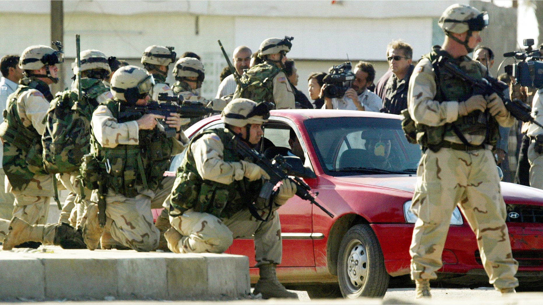 U.S. soldiers aim their rifles during a tense demonstration after a suicide car bomb exploded killing at least 50 people in Iraq.