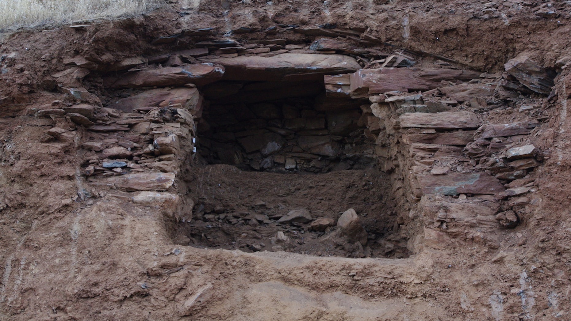 A tomb in northern Iraq held a pile of skeletons, including those dating back 2,400 years and more recent burials (shown here). The white dust is from the excavation of the more recent burials.