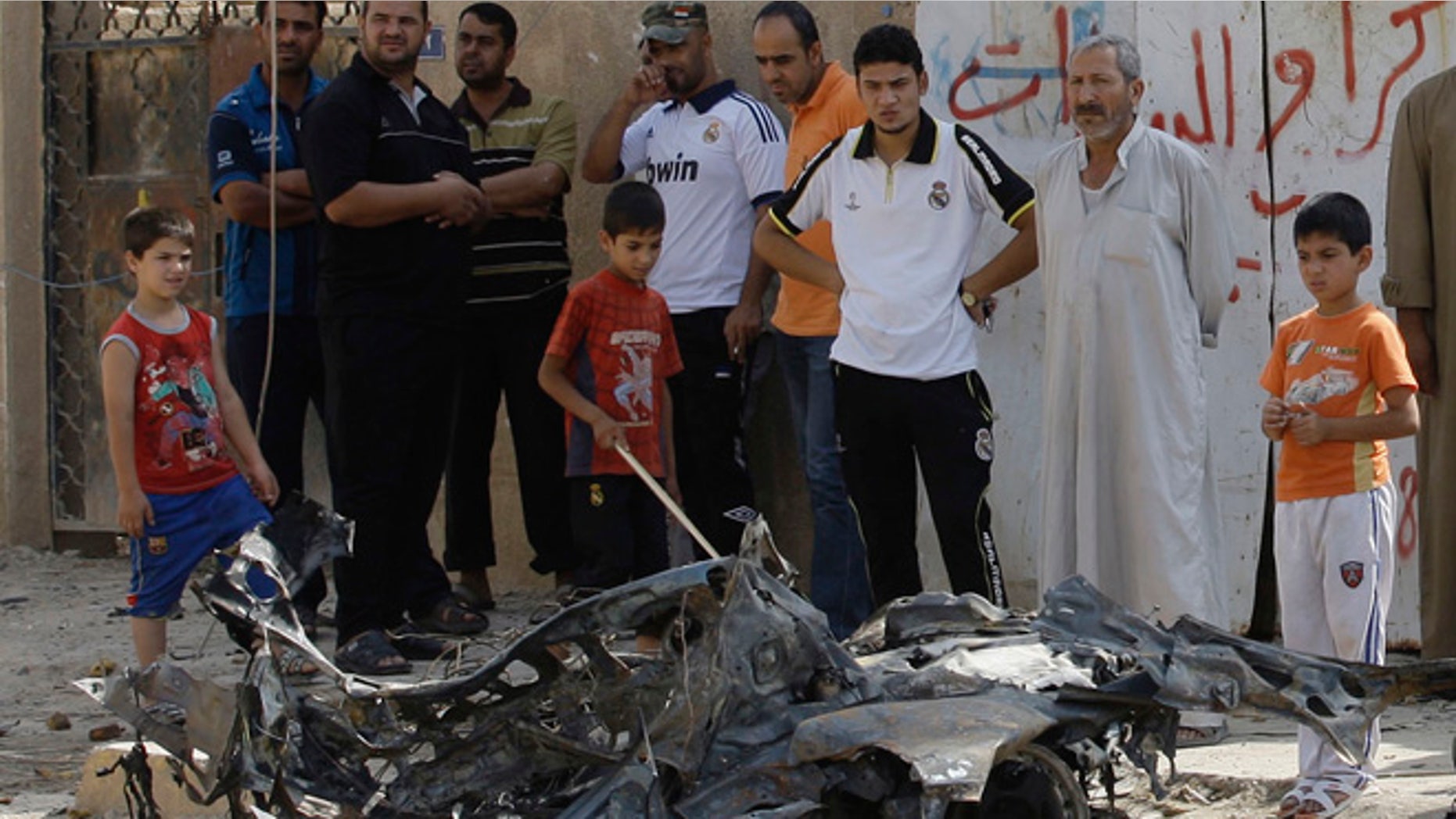 June 25, 2013: Iraqis inspect the aftermath of a car bomb attack at Baghdad's mostly Shiite neighborhood of Husseiniyah, Iraq. A series of evening bombings on near markets in and around Baghdad and other blasts north of the capital killed tens of people and wounded dozens of others Monday in the latest eruption of bloodshed to rock Iraq.