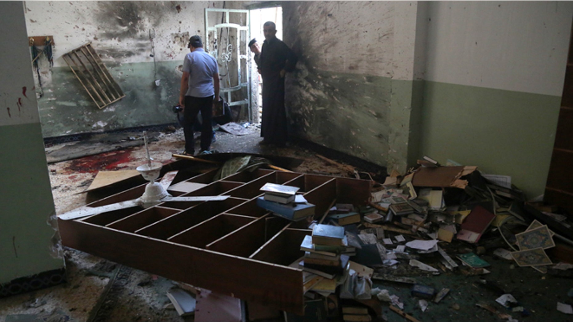 Aug. 25, 2014: Iraqis inspect the damage from an attack on the Imam Ali mosque in New Baghdad, Iraq. (AP/Khalid Mohammed)